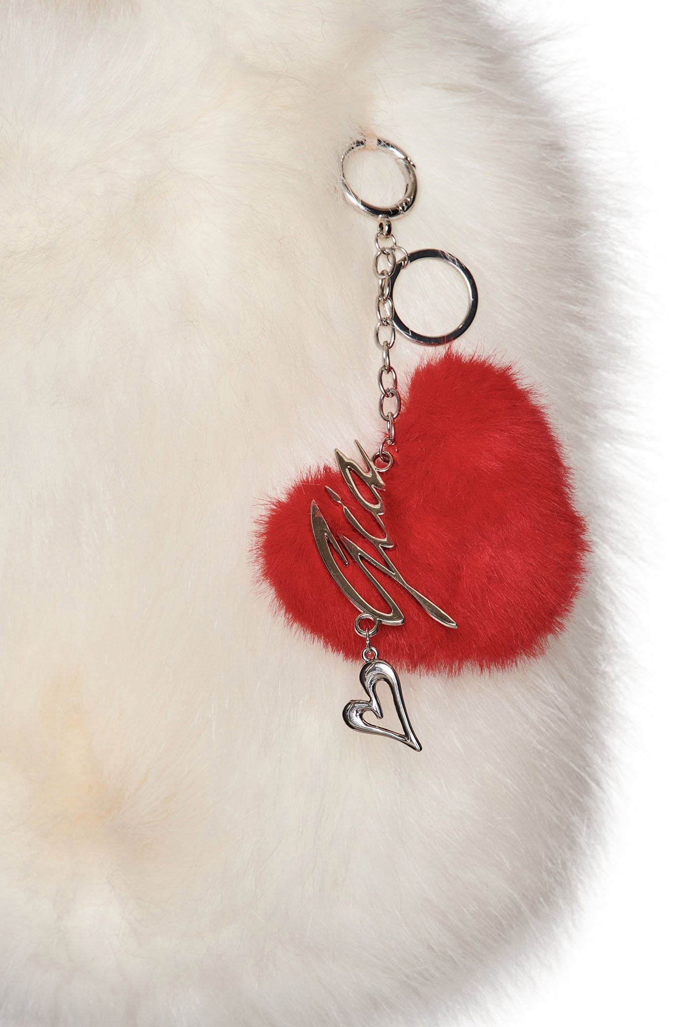 The VALENTINA KEYCHAIN - RED by I.AM.GIA includes a fluffy faux fur heart, a silver outline, and metallic script, all with an attached keychain.