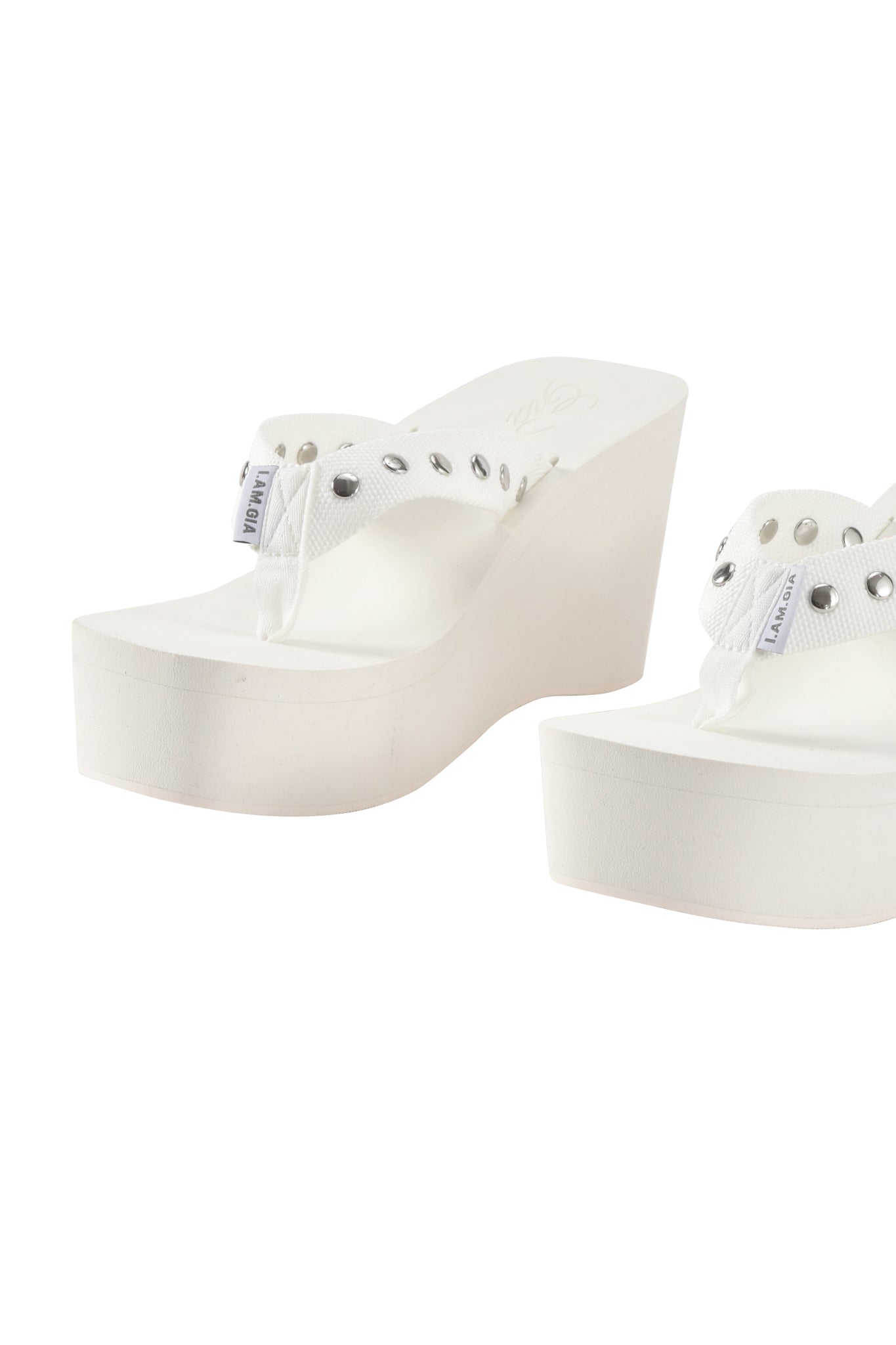 The SHELBY STUDDED FLIP FLOP 2.0 - WHITE by I.AM.GIA features platform wedge sandals with silver studded strap details, displayed against a white background.