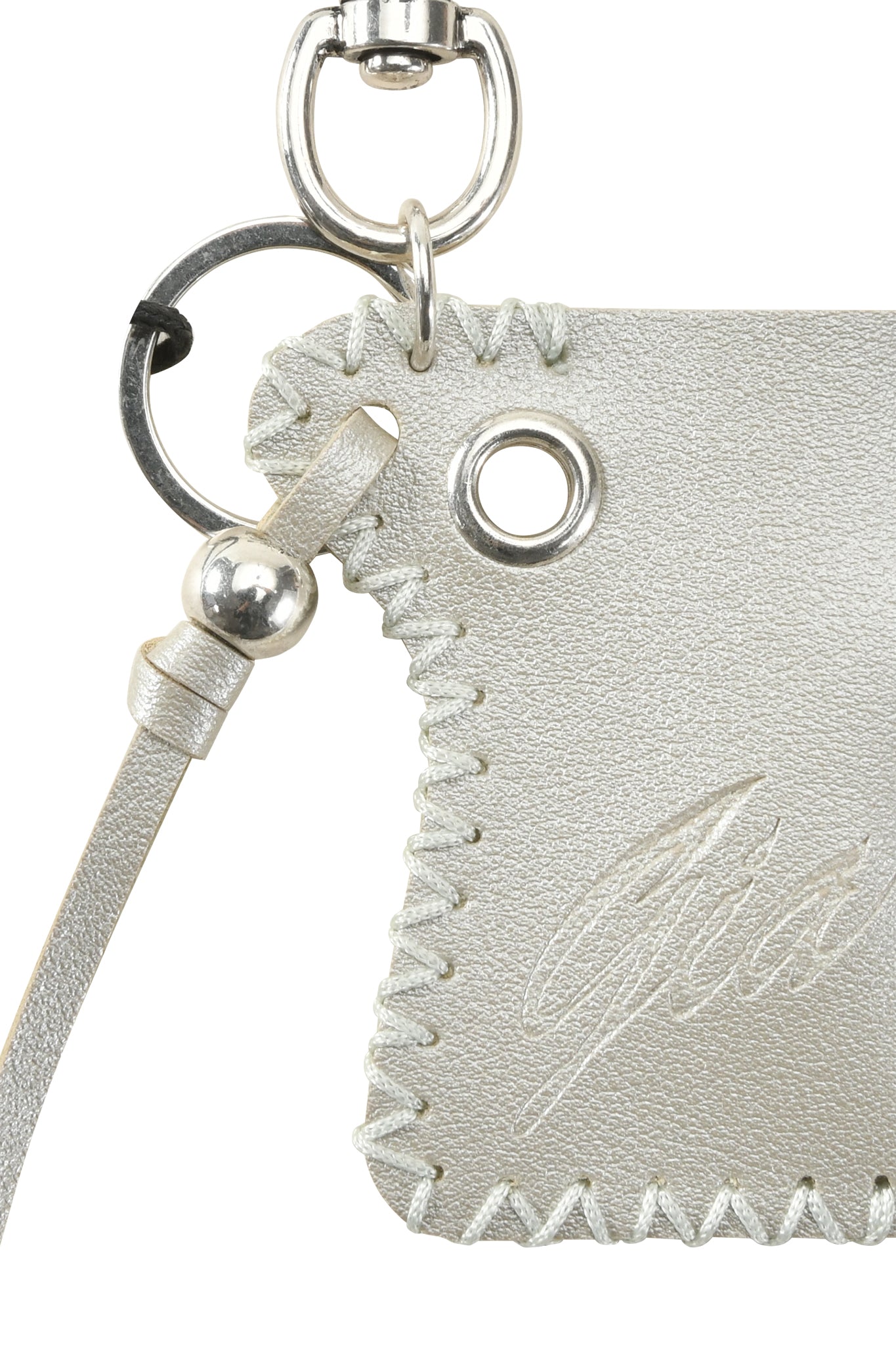 Close-up of the I.AM.GIA VENUS LIGHTER KEYCHAIN - SILVER: textured light gray faux leather with white stitching, metal grommet, leather strap with metal bead, and partially visible embossed signature.