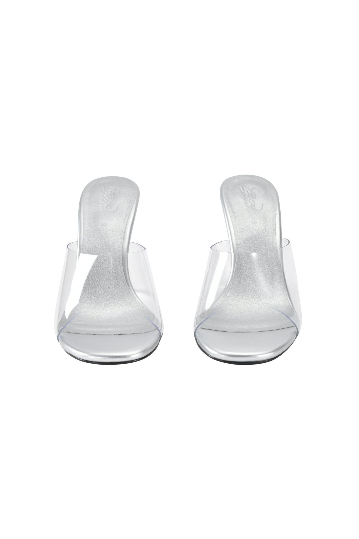 The I.AM.GIA RHEA CLEAR WEDGE HEEL - TRANSPARENT features clear vinyl straps and a transparent wedge heel, shown from the front on a white background.