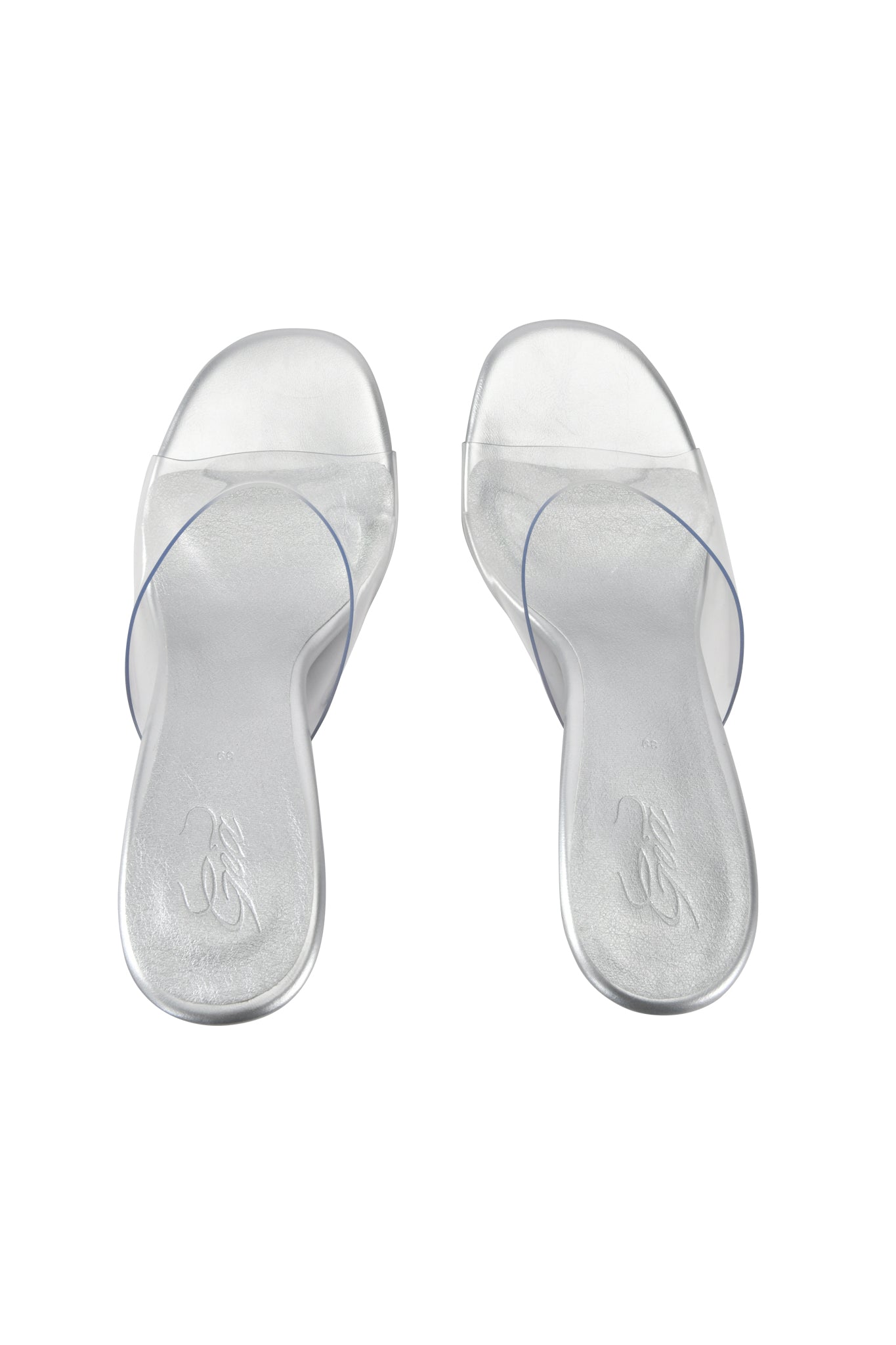 The I.AM.GIA RHEA CLEAR WEDGE HEEL sandals, featuring transparent vinyl straps, a mule silhouette, and silver soles, are displayed side by side on a white background.
