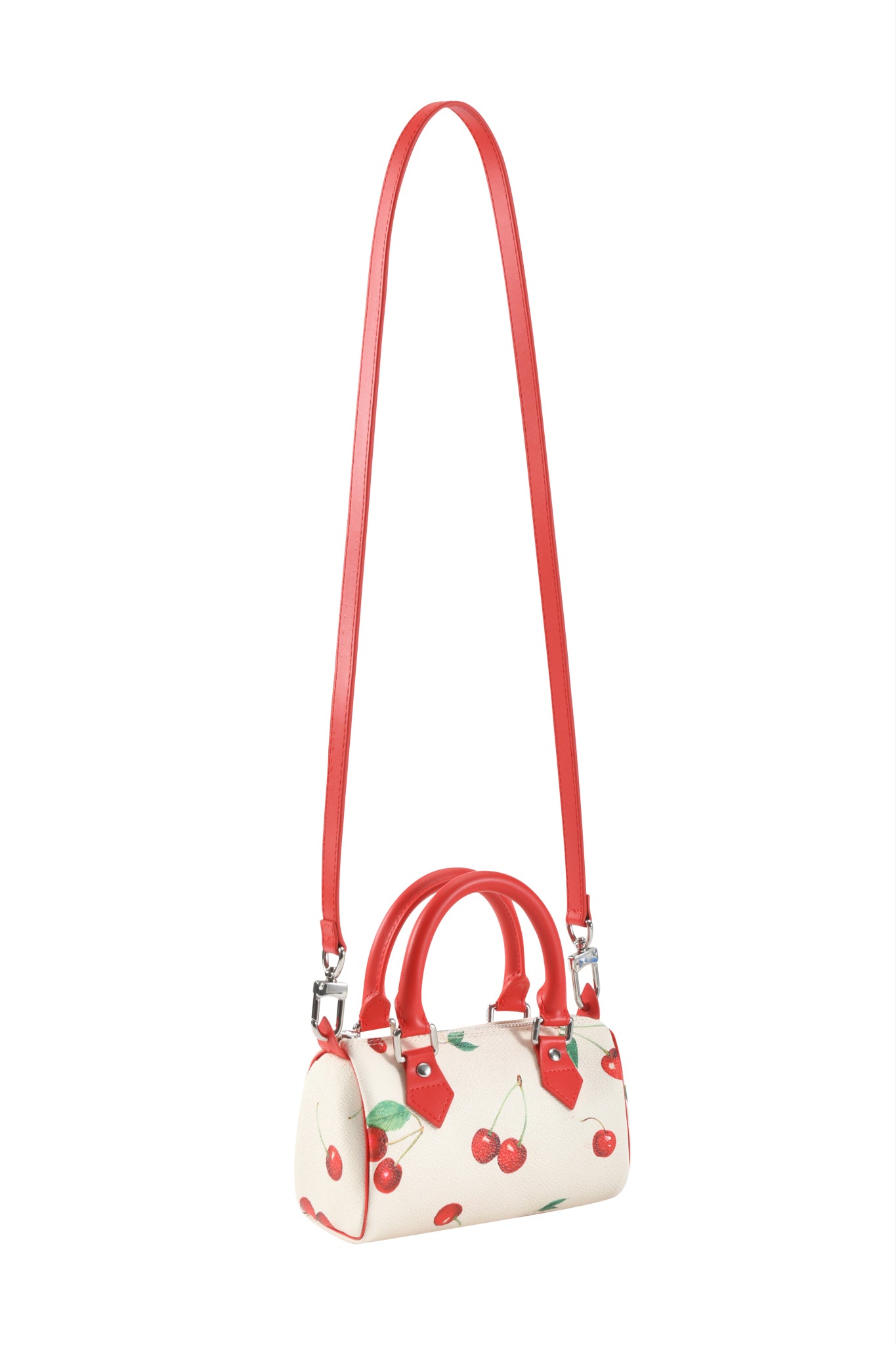 The I.AM.GIA NIKA MINI BAG - CHERRY ON TOP is a small white barrel purse with red handles, Cherry on Top print, and a removable long shoulder strap for versatile styling.