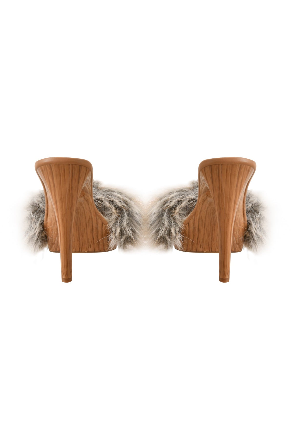 A pair of I.AM.GIA NICKY HEEL - FAUX FUR TAN high-heeled slip-on mules, featuring wooden heels and plush tan faux fur strap accents, shown from the back against a white background.