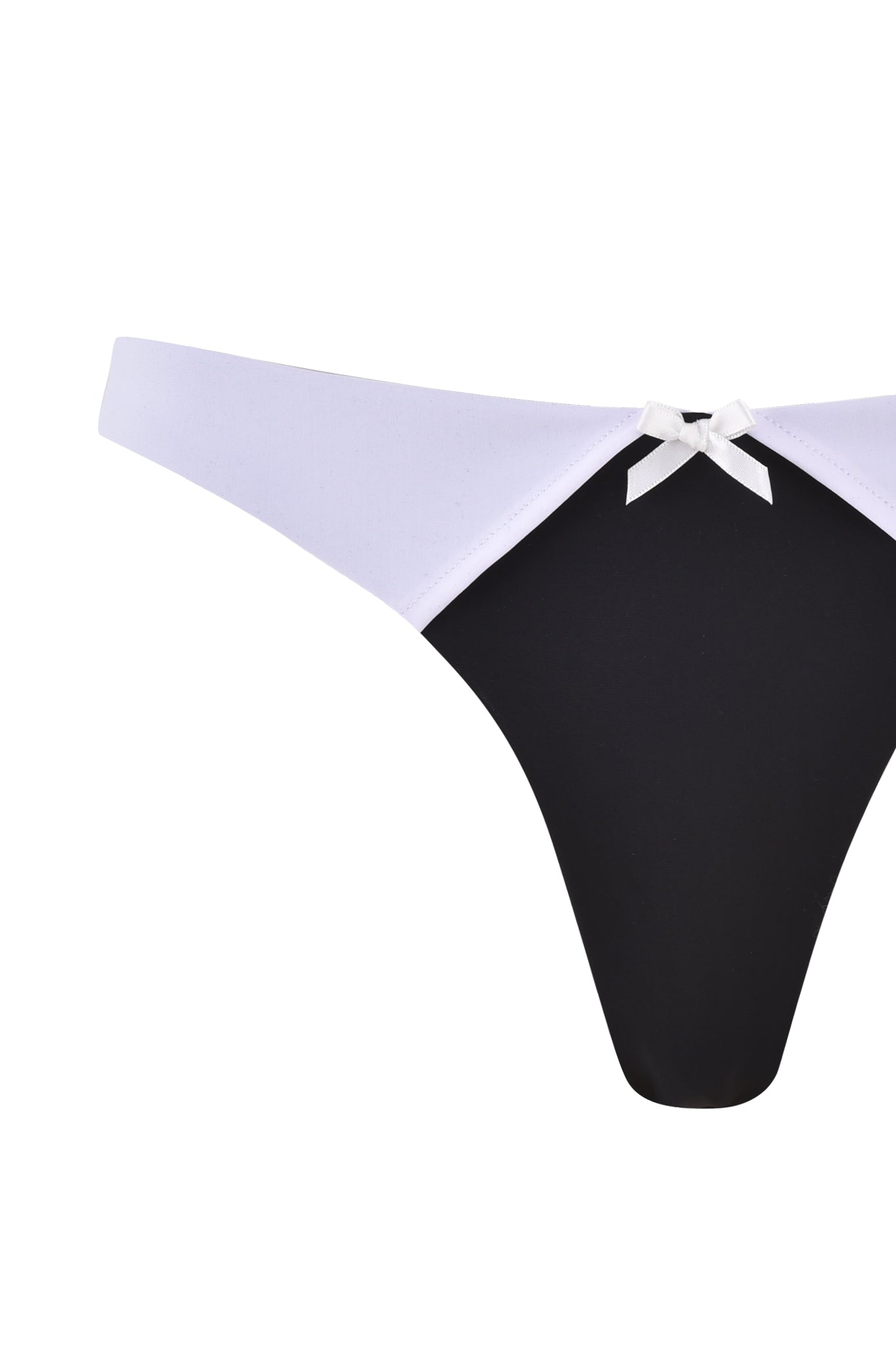 A close-up view of the I.AM.GIA DION TUXEDO BIKINI BOTTOM - BLACK : WHITE. The main fabric is black, while the sides and low-rise waist are a contrasting white. A small white bow embellishment is adorning the center of the waistband.