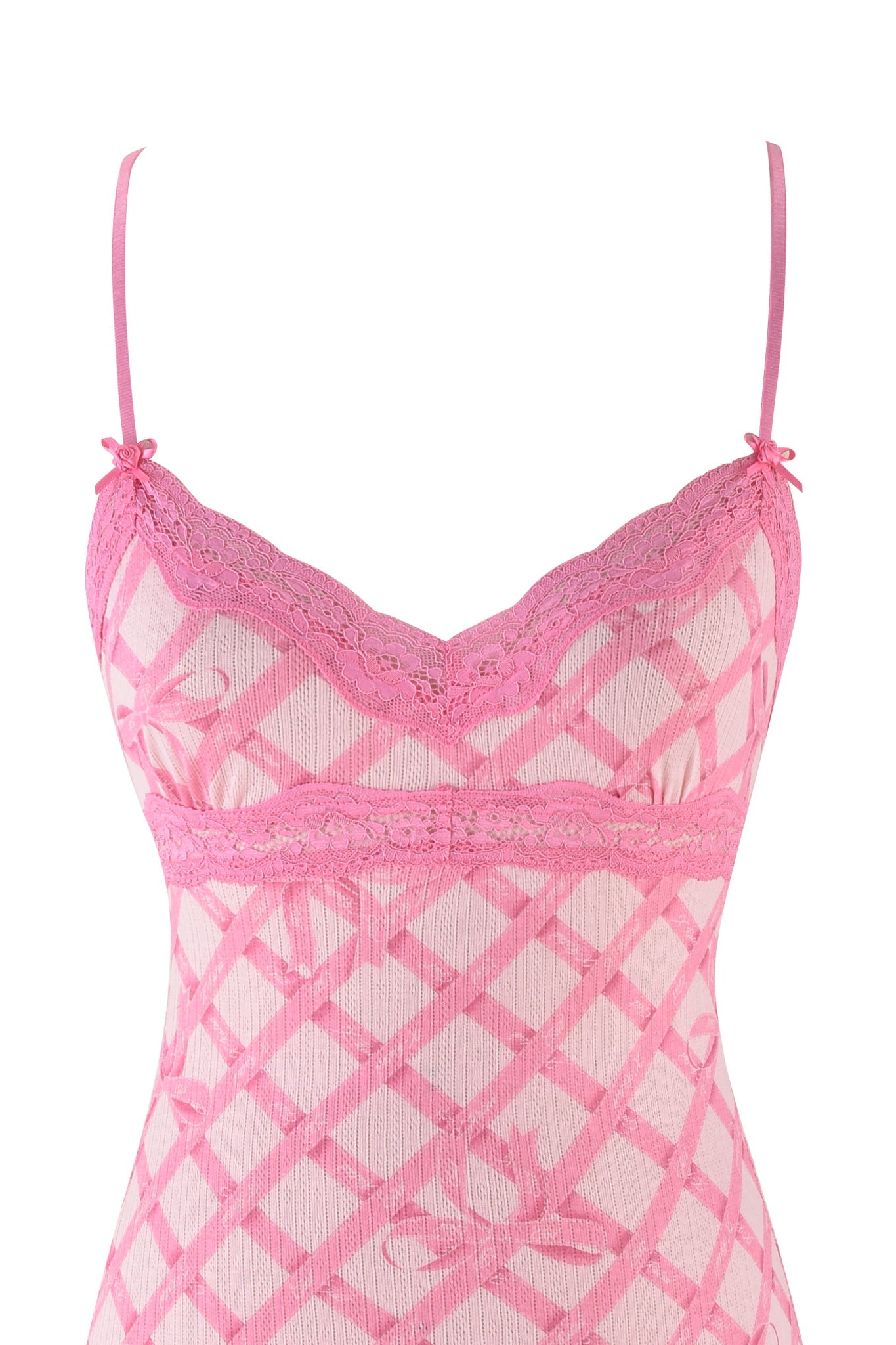 The I.AM.GIA CASSIA SLIP DRESS in pink is a bodycon with thin straps, featuring a diamond pattern on white. It has delicate lace along the neckline and small bow accents on the straps, echoing an elegant pink wrapping paper print.
