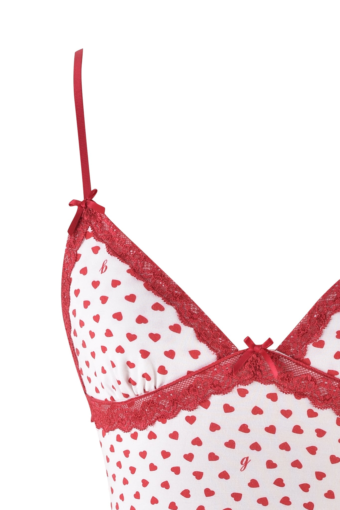 Close-up of the I.AM.GIA KENDRA TANK - WHITE : DIGITAL : HEARTBEAT, showcasing a body-con silhouette with a white surface adorned with small red hearts. It features red lace trim, adjustable spaghetti straps, and two small red bows on top.