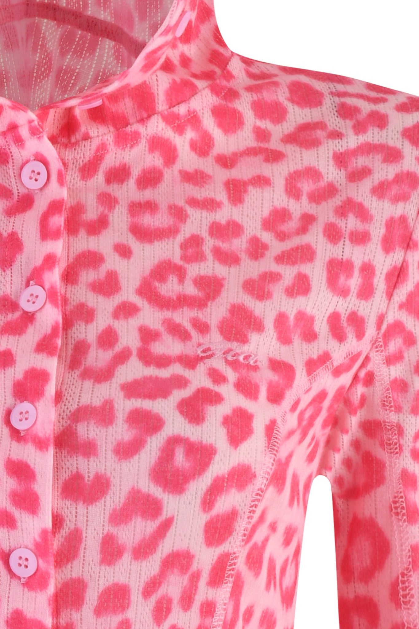 Close-up of the MIA HOODIE in Pink Leopard by I.AM.GIA, featuring a hot pink leopard print with buttons on the front. The fabric showcases a bold pattern, complemented by subtle text on the chest area—ideal for pairing with a sleek bodycon silhouette for a chic look.