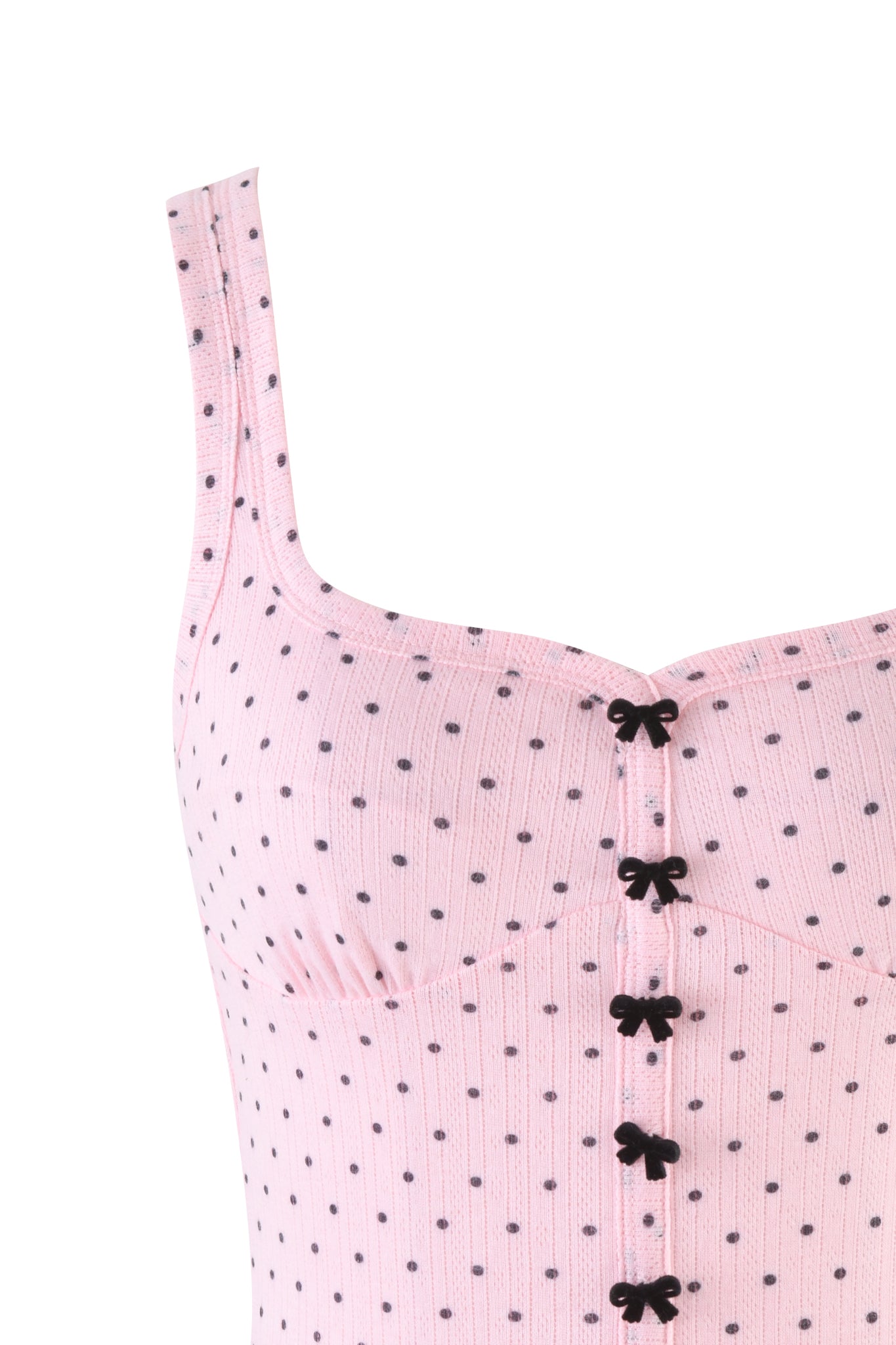 Close-up of the LAUREL TANK - LIGHT PINK by I.AM.GIA, a baby pink ribbed tank top with black polka dots, decorative black bows down the front, wide straps, high-stretch fabric, and a sweetheart neckline.