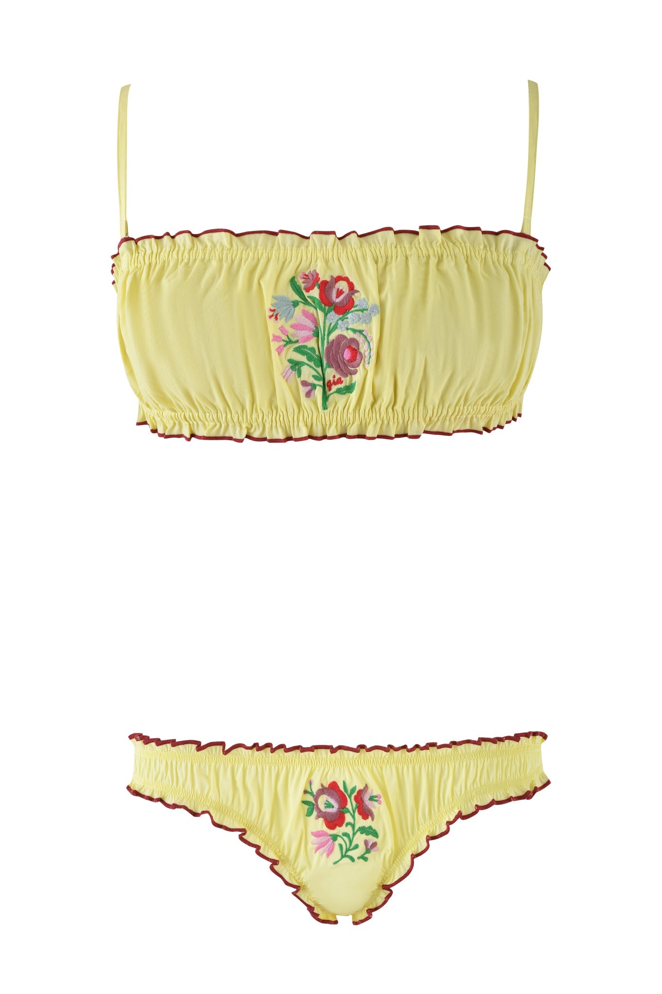 The CLOVER SET - YELLOW by I.AM.GIA includes a yellow bandeau bralette and matching panties adorned with red, pink, and green floral embroidery at the center and elegant red trim. This strapless set combines vibrant sophistication and charm.