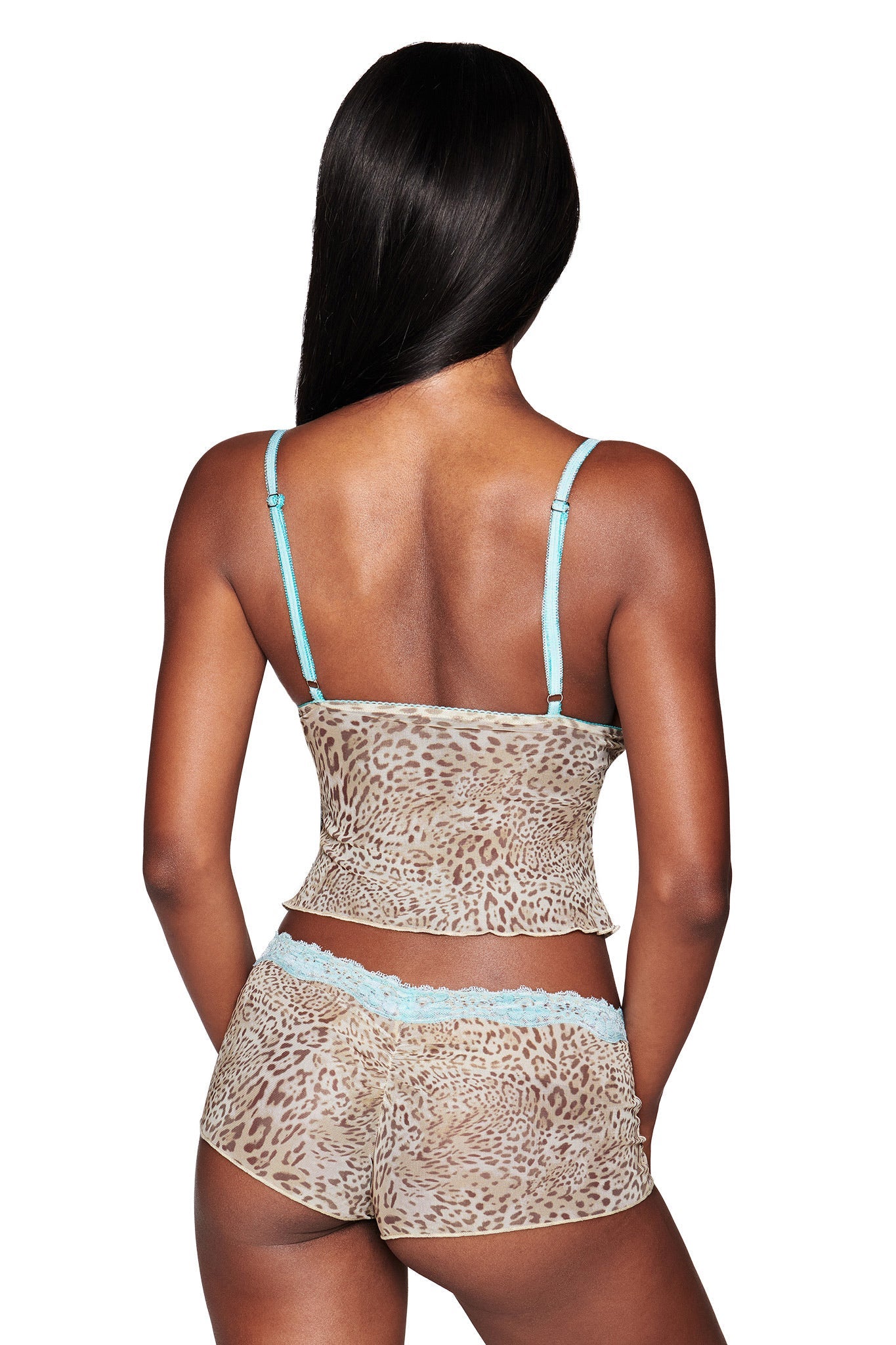 A woman with long, straight hair is seen from the back wearing the I.AM.GIA TASHA SHORT - LEOPARD LIMBO set: a leopard print camisole with light blue straps and matching low-rise hot shorts trimmed with blue lace.
