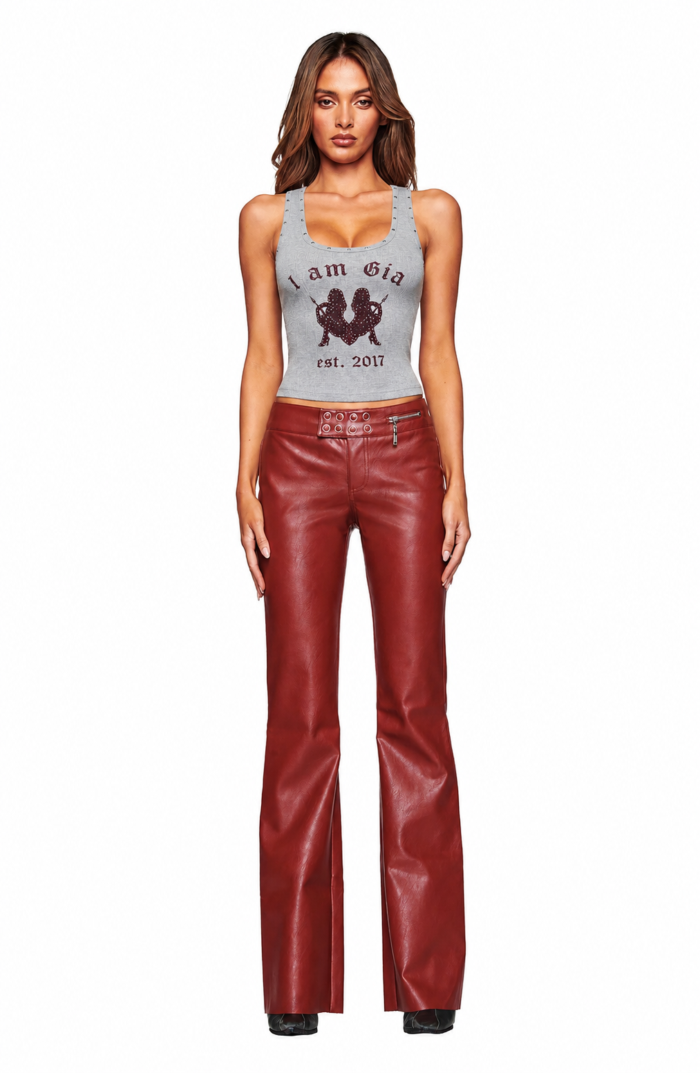 A woman stands facing forward in a gray graphic tank top, wearing I.AM.GIA REIKA PANT - DARK RED, paired with black shoes against a plain white background.