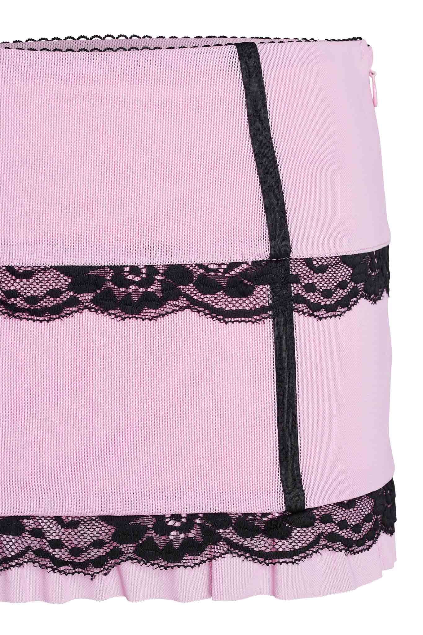 Close-up of the SUTRA SKIRT - PINK by I.AM.GIA, featuring decorative black lace trim that embodies edgy elegance. The design showcases black vertical and horizontal bands, complemented by a ruffled edge at the bottom. The intricate lace pattern adds a sophisticated touch to this stunning piece.
