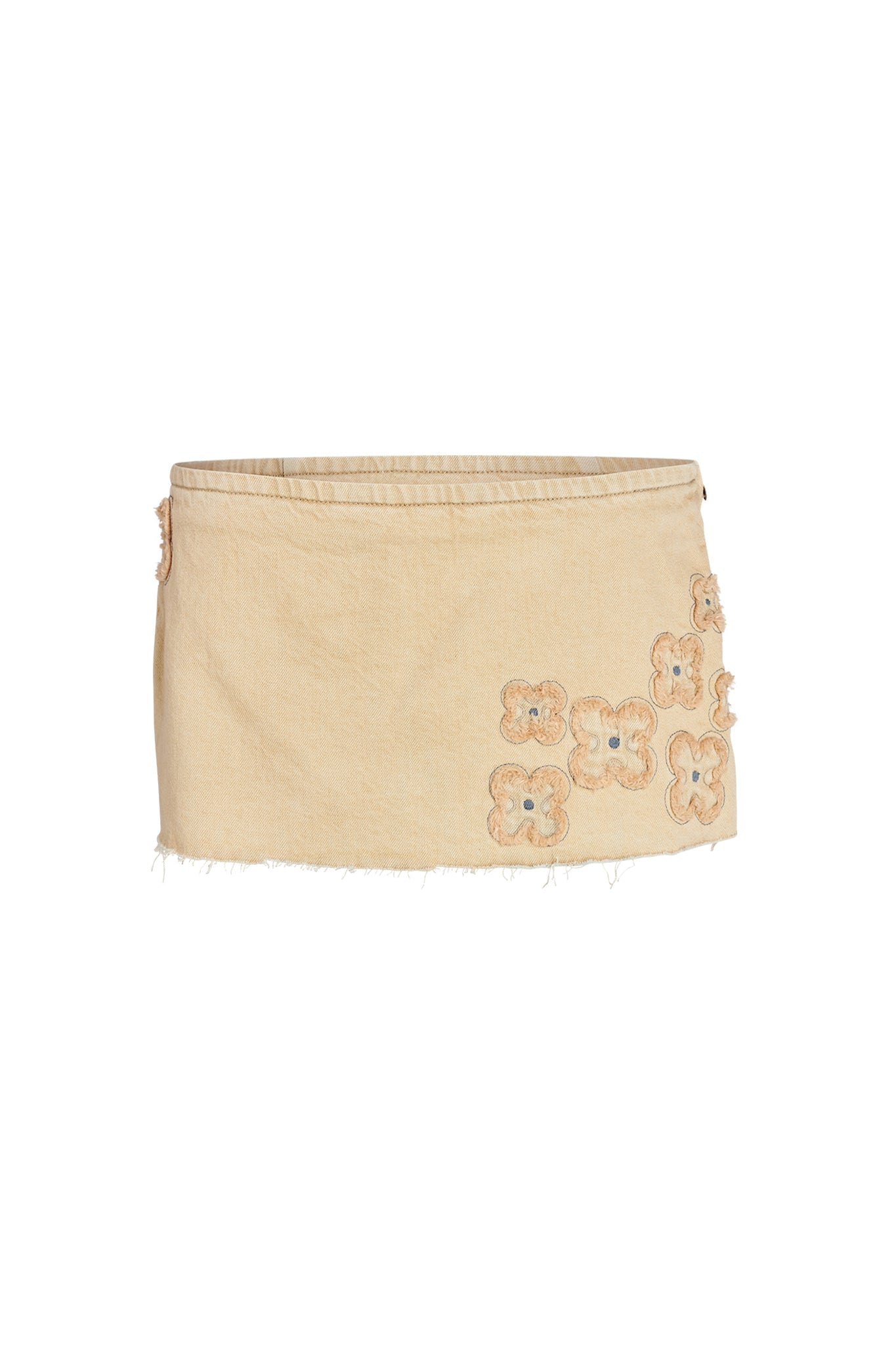 The FAUNA MINI SKORT - BEIGE : TAN DENIM by I.AM.GIA features a raw, unfinished hemline with embroidered floral appliqués on the front. The light beige flowers with darker center accents add a delicate decorative touch to its simplistic design.