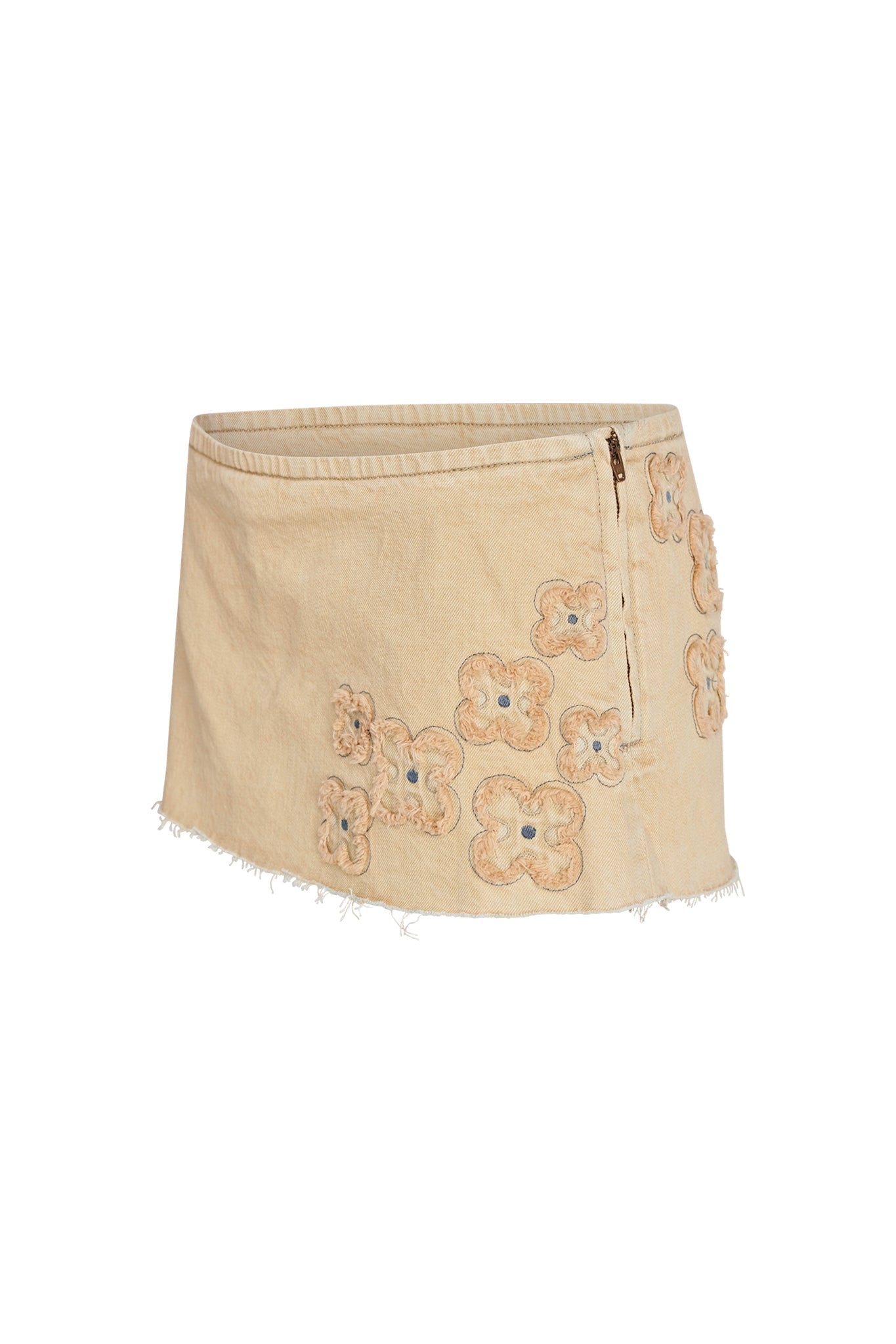 A chic mini skort by I.AM.GIA, officially named the FAUNA MINI SKORT - BEIGE : TAN DENIM, featuring a beige color with a frayed hem and adorned with cream and tan floral appliques. The skort also includes a zipper on the right side.