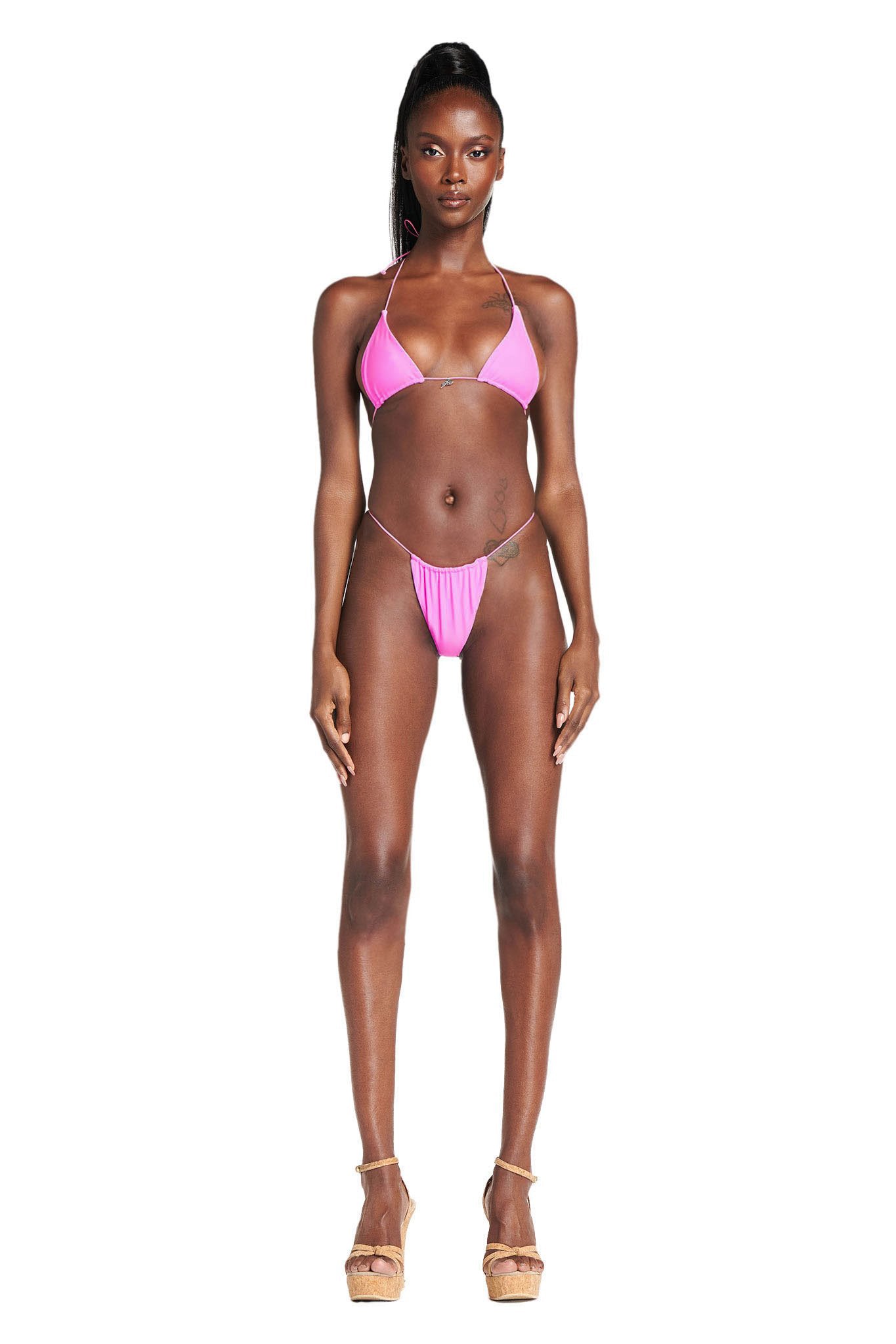 A woman faces forward against a plain white background, wearing the I.AM.GIA BAMBI BIKINI BOTTOM in pink and beige platform heels.