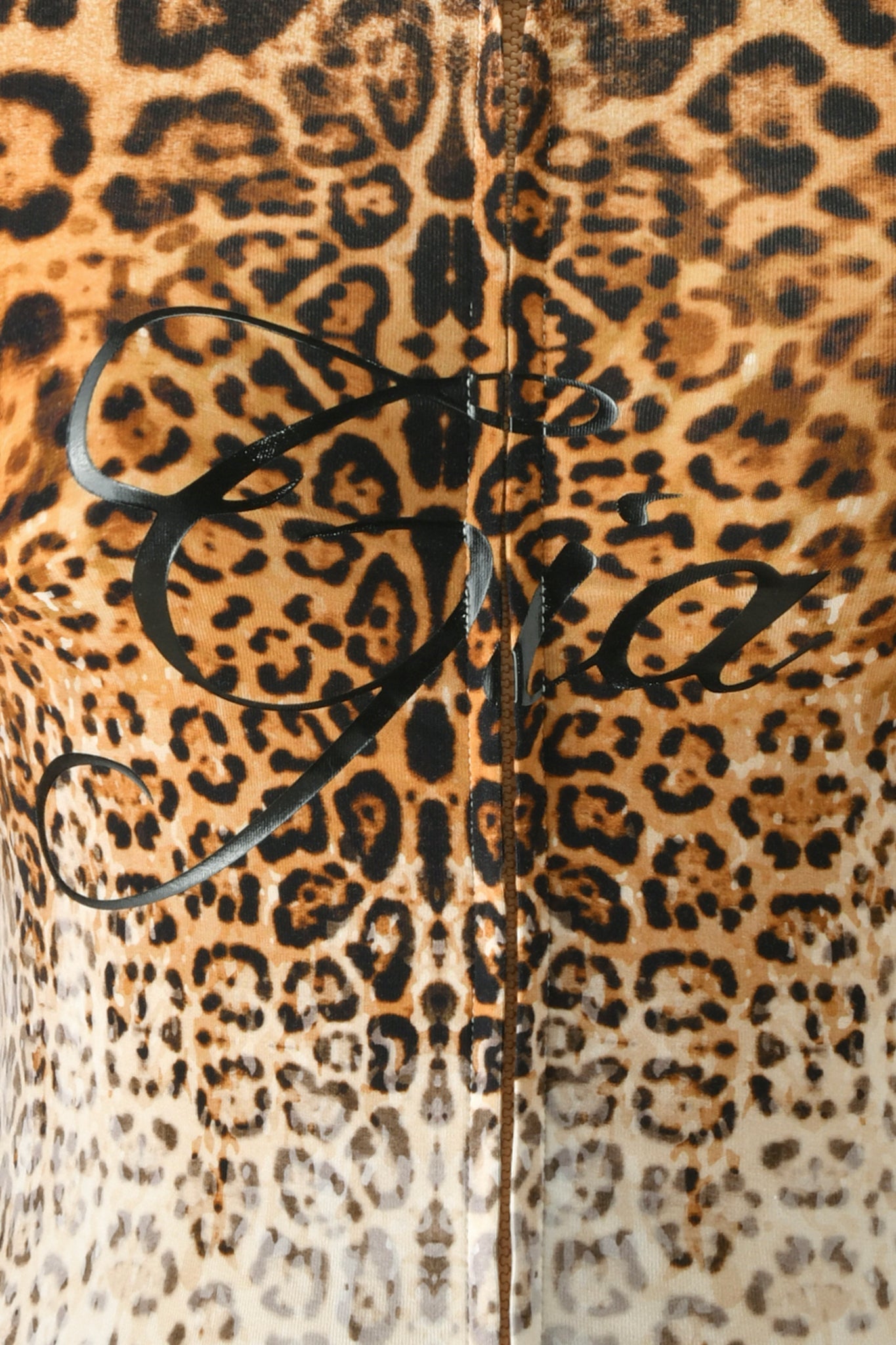 Close-up of the BLARE HOODIE - CREAM FADED PANTHERA by I.AM.GIA, featuring a cream-toned panthera print fabric with black cursive writing across the center.