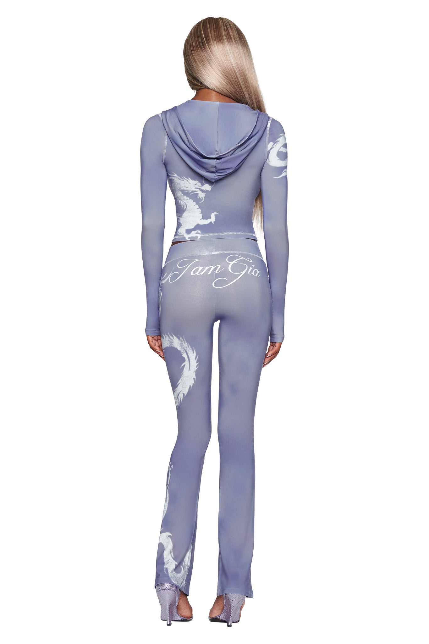 A person with long blonde hair, seen from behind, wears fitted, sheer lavender attire and pairs it strikingly with the I.AM.GIA BLARE TRACKPANT in Steel Blue Dragon for an edgy twist.