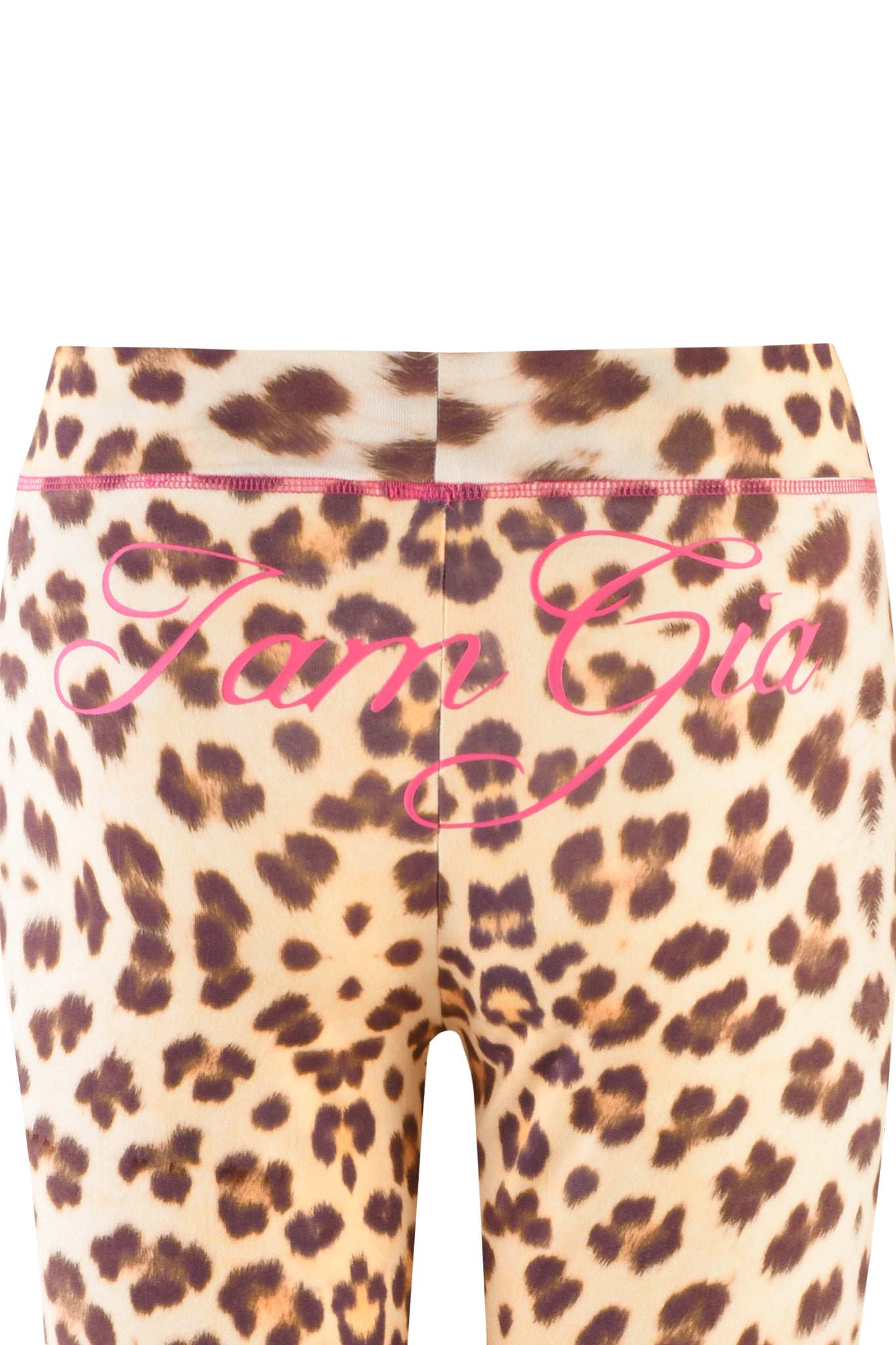 Close-up image of the back of a pair of I.AM.GIA Blare Trackpants in Wild Card Leopard print. Across the low-rise waistband, the text "I am Gia" is written in pink cursive font. The trackpants feature a seam running down the center.