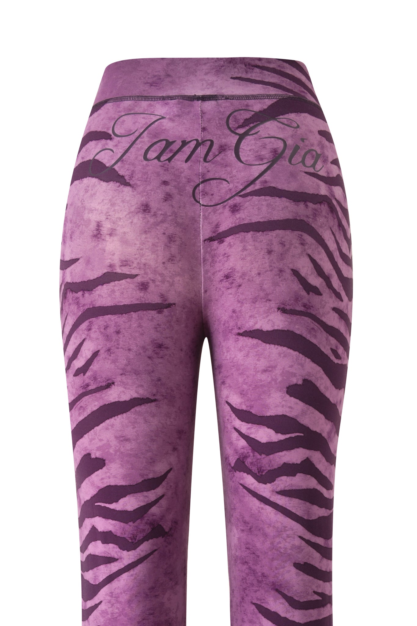 The BLARE TRACKPANT - PLUM WILD SIDE by I.AM.GIA is a purple high-waisted legging with black tiger stripes and "I am Gia" in cursive on the waistband.