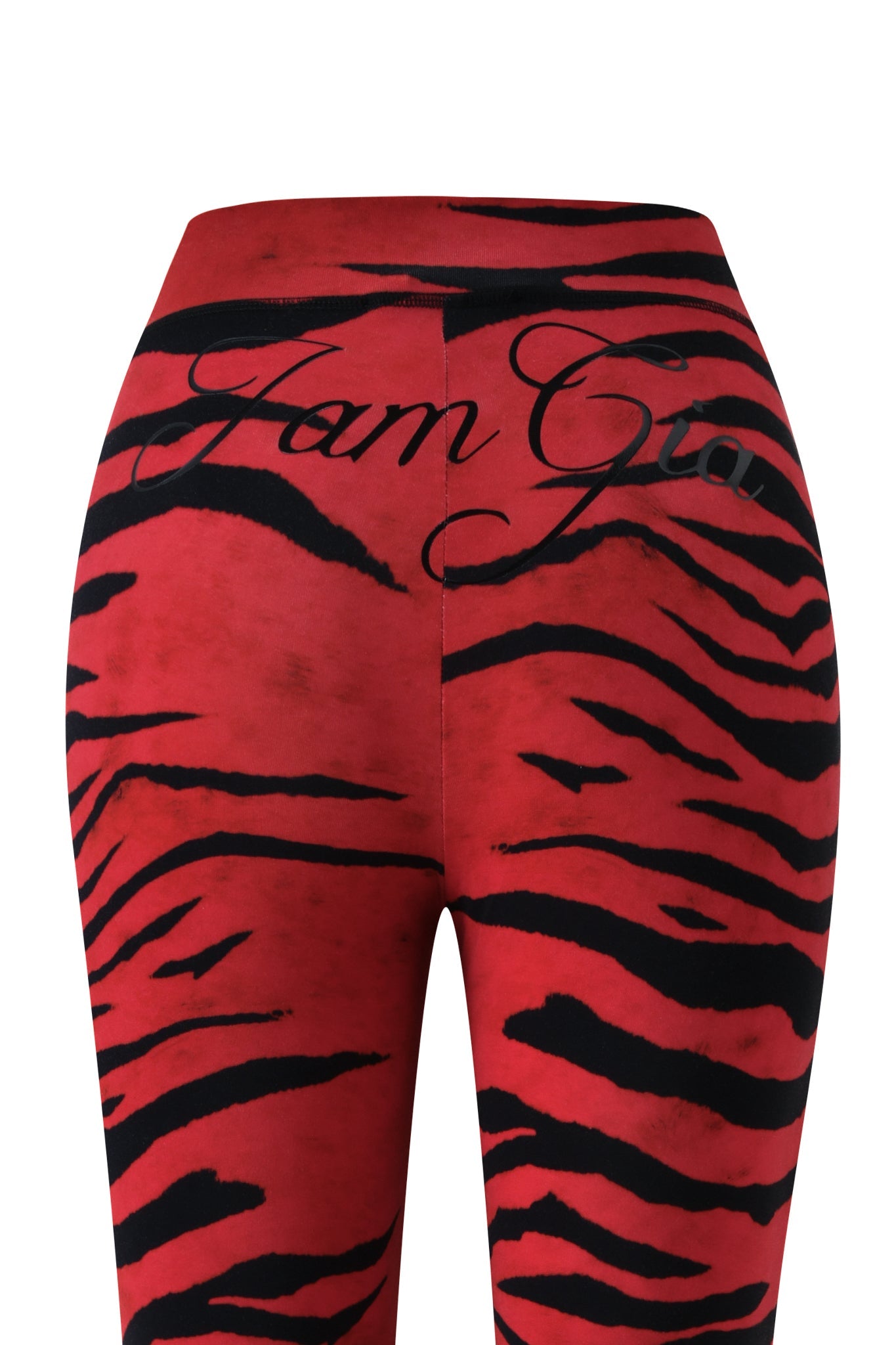 The BLARE TRACKPANT - RED WILD SIDE by I.AM.GIA features a bold red and black zebra print, with “I.AM.GIA” written in black cursive across the waistband. Reminiscent of the iconic Blare Trackpant style, this striking design is showcased from a back view to highlight its unique pattern and statement details.