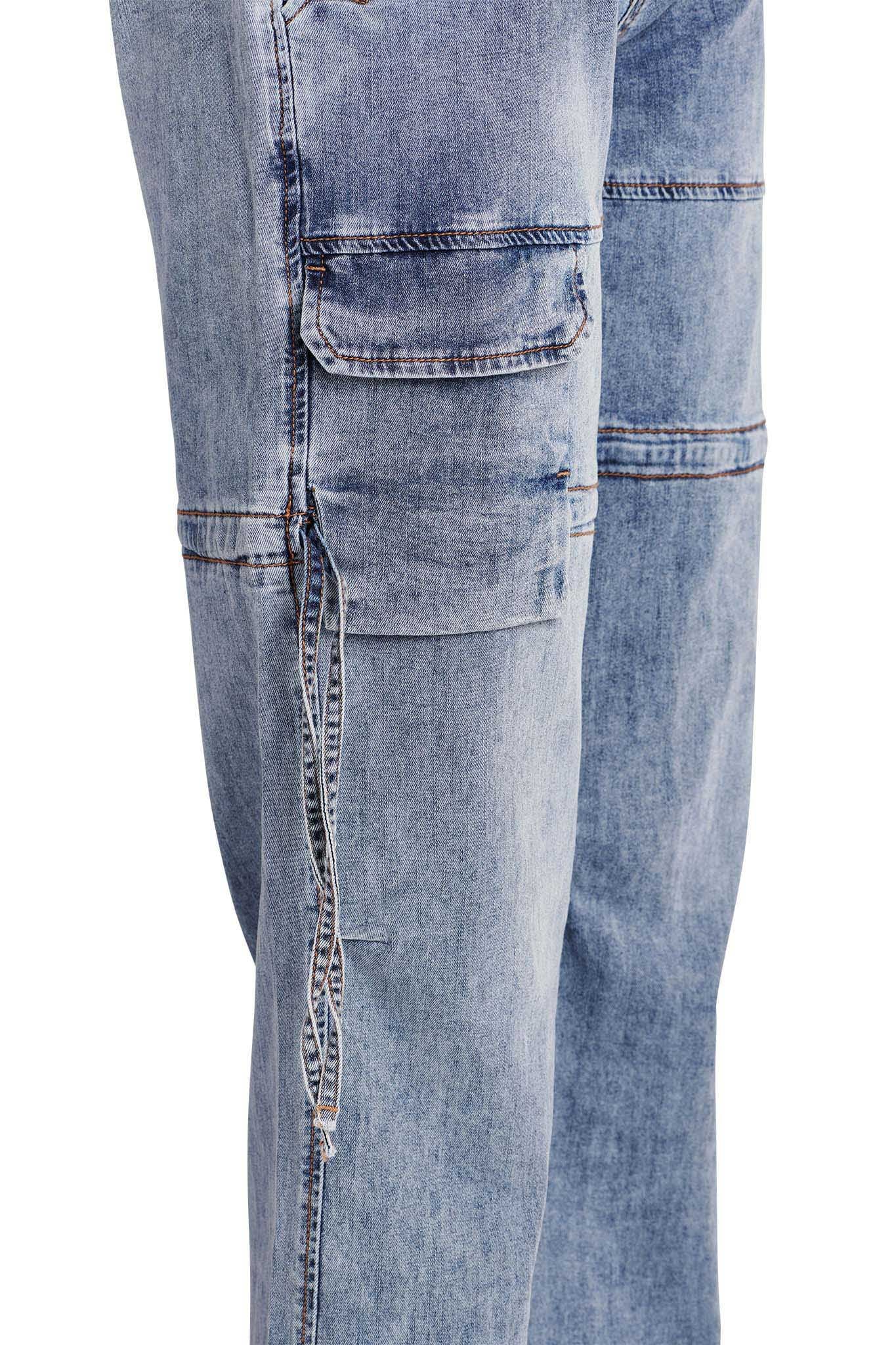 Close-up of the NAIMA CARGO PANT - DENIM by I.AM.GIA. These light blue denim pants feature detailed stitching, multiple pockets with flap closures on the thigh, and a relaxed fit. The fabric has a slightly worn, distressed look with subtle variations in color.