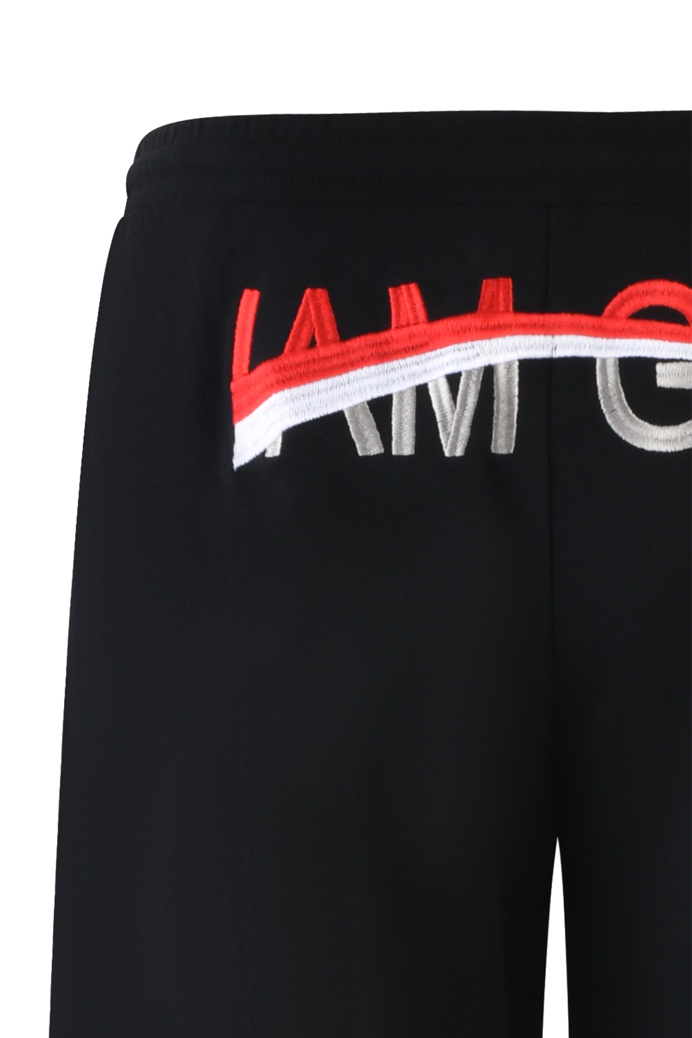Close-up of the JUSTINE PANT - BLACK with the partial phrase "IAM" visible near the waistband. The letters "I" and "A" are red, while the "M" is white and partially covered by a red-and-white striped detail extending across the waistband, echoing I.AM.GIA’s bold design aesthetic.