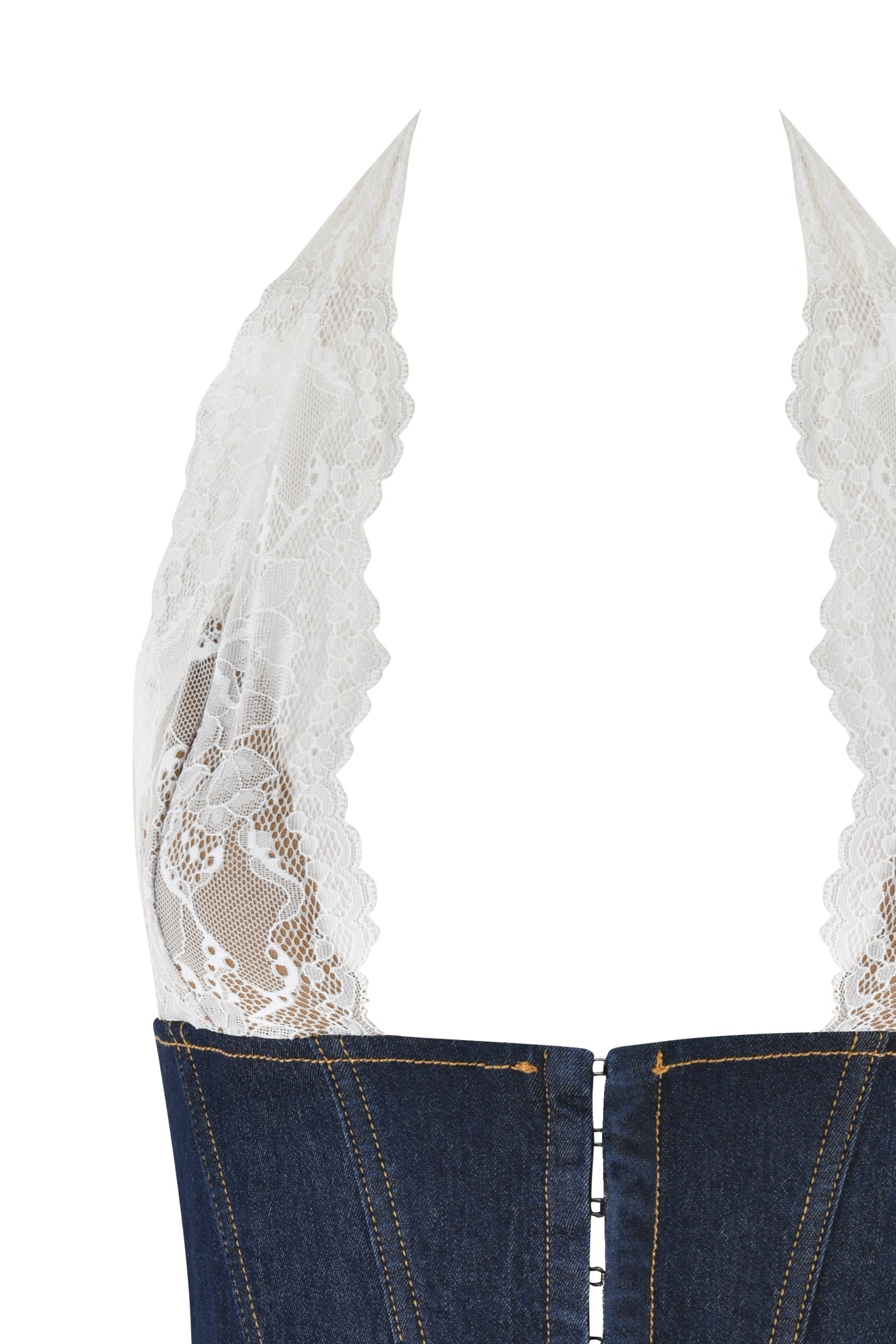 A close-up view of the ELLENA CORSET - BLUE : DARK WASH by I.AM.GIA showcases prominent white lace halter straps with a floral pattern. This stretch denim corset features visible stitching details and a row of metal hook-and-eye closures along the front, all set against a white background.