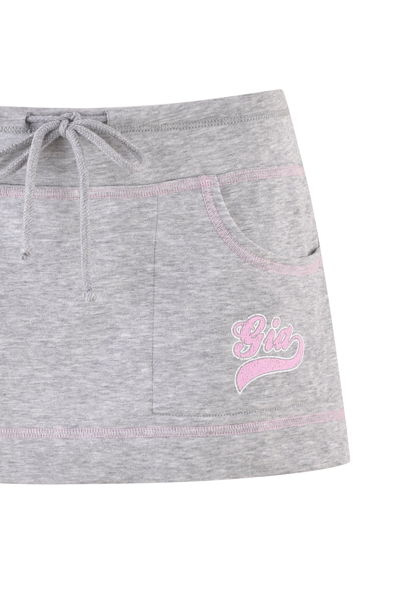 The EZORA SKORT 2.0 - GREY by I.AM.GIA is a mini skort with a low-rise waistline and drawstring, featuring two front pockets and "Gia" embroidered in pink on the front. Light pink stitching adds a chic touch to the pockets and waist.
