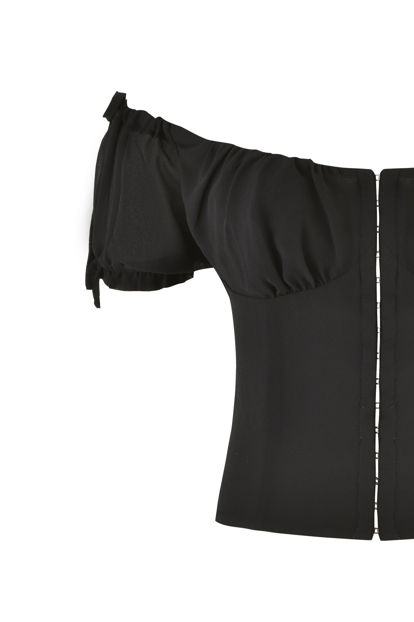 The VALERIE GEORGETTE BUSTIER in black by I.AM.GIA is an off-the-shoulder top featuring puffed short sleeves and a visible side closure. The smooth fabric accentuates its bodycon fit, and the design is tailored for a sleek look. The image highlights the upper left side of the garment.