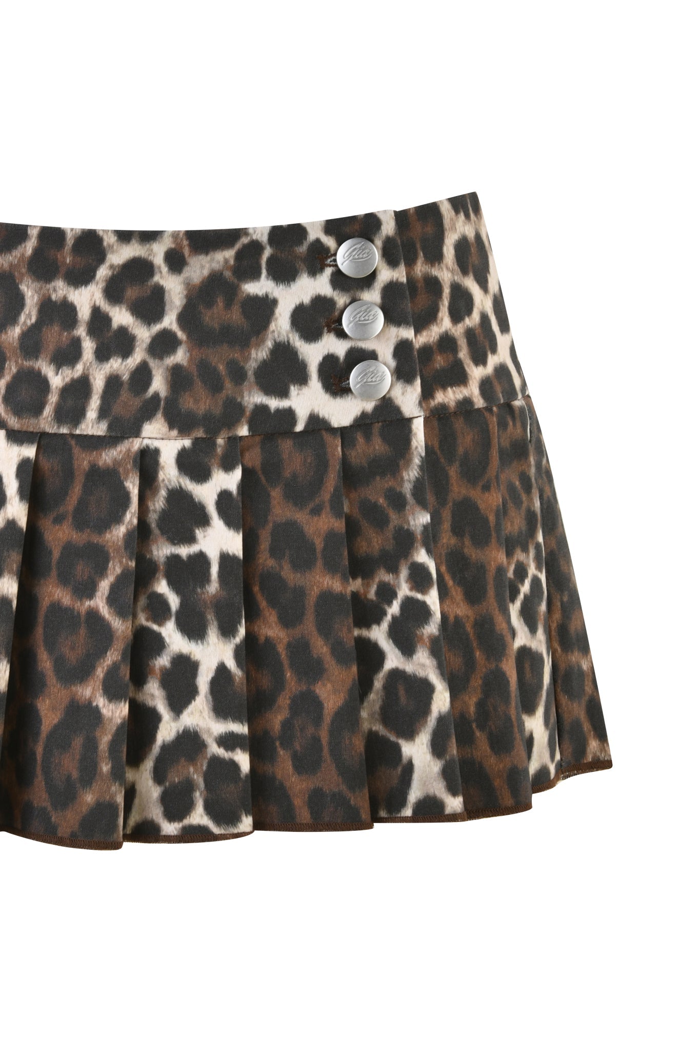 The REMINI SKORT 2.0 - NEUTRAL : LEOPARD by I.AM.GIA showcases a custom neutral tone leopard print with a pleated mini skirt design. It features three silver buttons on a horizontal waistband, creating a striking animal print look.