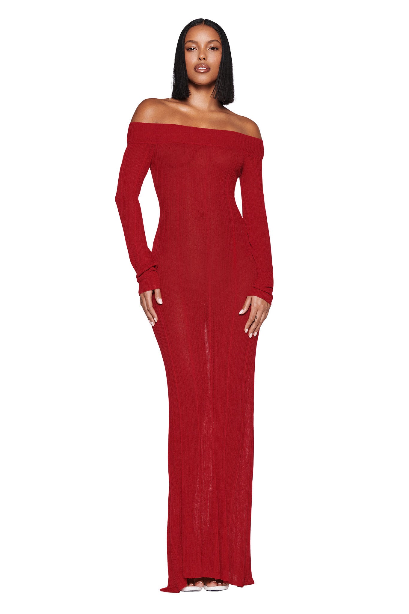 A person models the form-fitting ANASTASIA MAXI DRESS in burgundy by I.AM.GIA, standing against a plain white background. The elegant dress features an off-the-shoulder design and reaches the floor, while the individual with straight hair gazes directly into the camera.