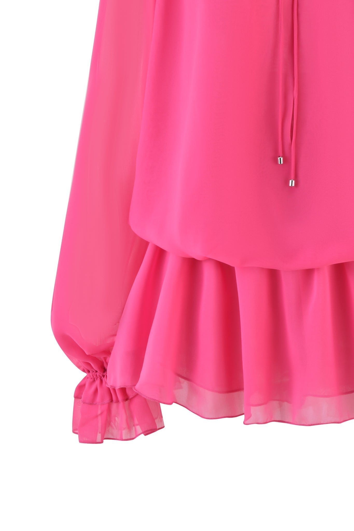 A close-up of the JAZMIN PLAYSUIT in hot pink by I.AM.GIA showcases long, loose sleeves gathered at the cuffs. The mini playsuit features ruffled layers on the lower part, with fabric that appears light and slightly sheer.