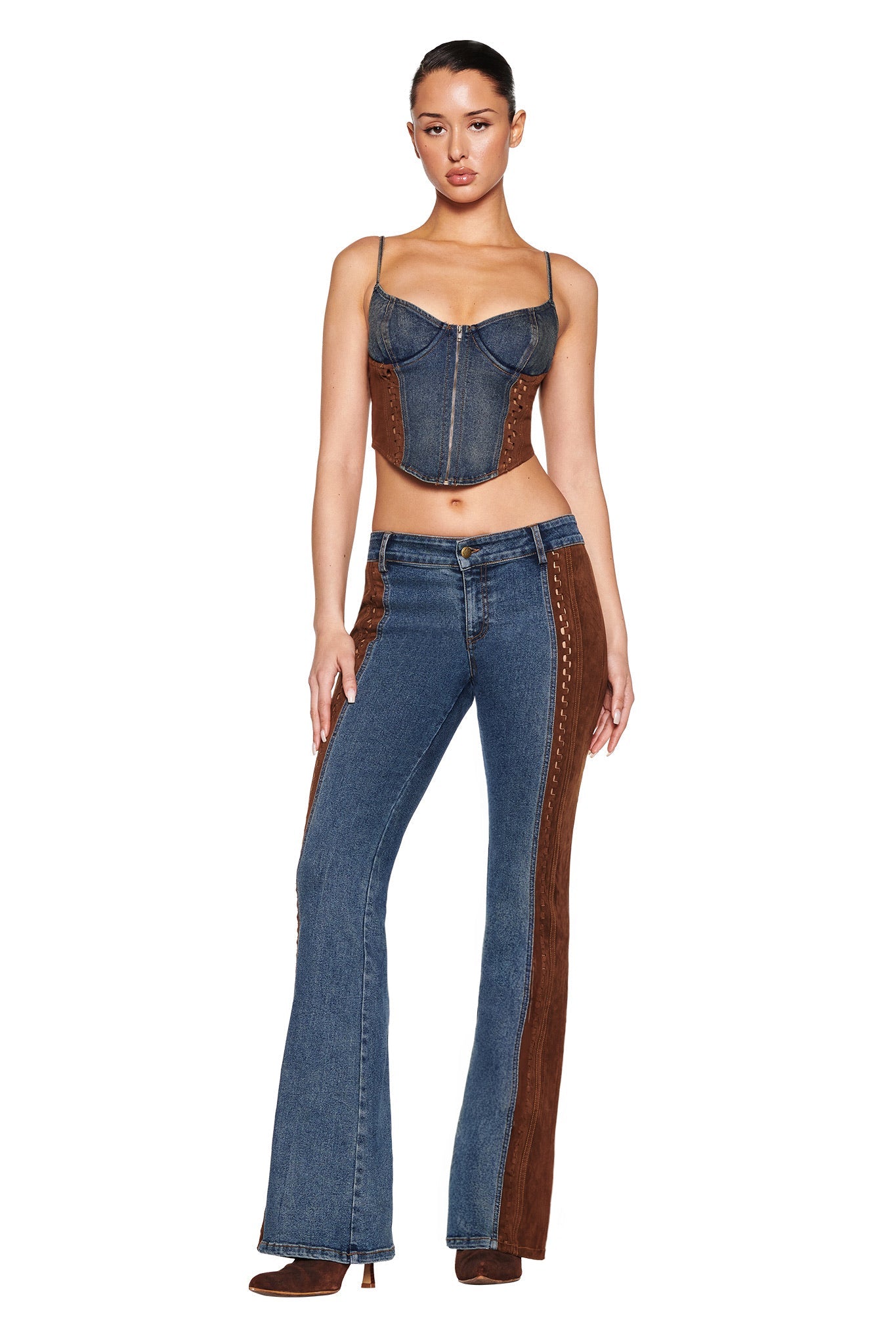 A person stands against a white background wearing an I.AM.GIA denim corset top and the FORREST PANT in blue with a medium wash and brown suede contrast, complemented by brown heeled boots.