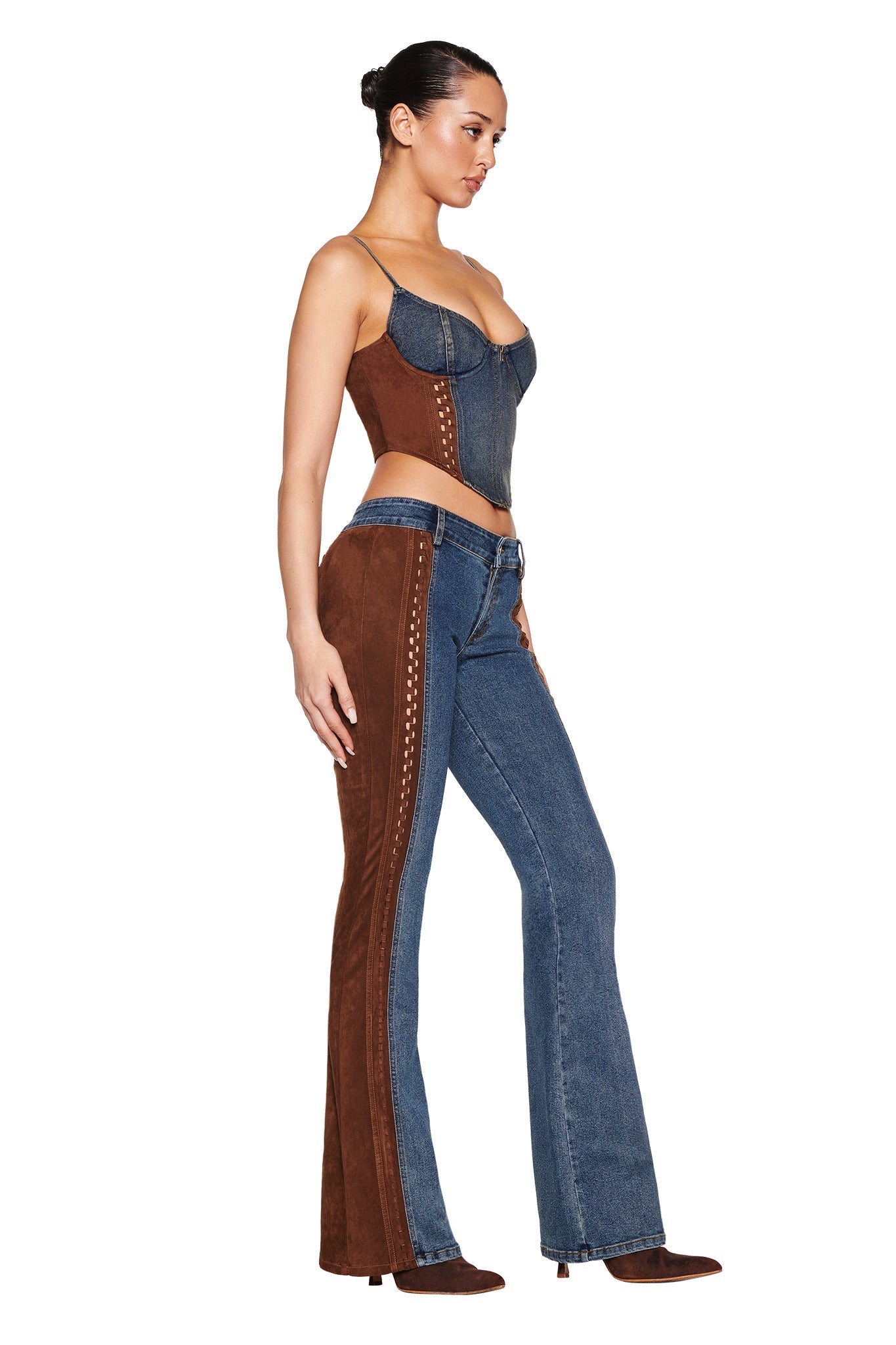 A model showcases the I.AM.GIA "FORREST BUSTIER - BLUE : MEDIUM WASH," featuring flared pants and a corset-style top with adjustable straps. The outfit's contrasting textures, stitching details, and vintage washed effect stand out in her profile pose.
