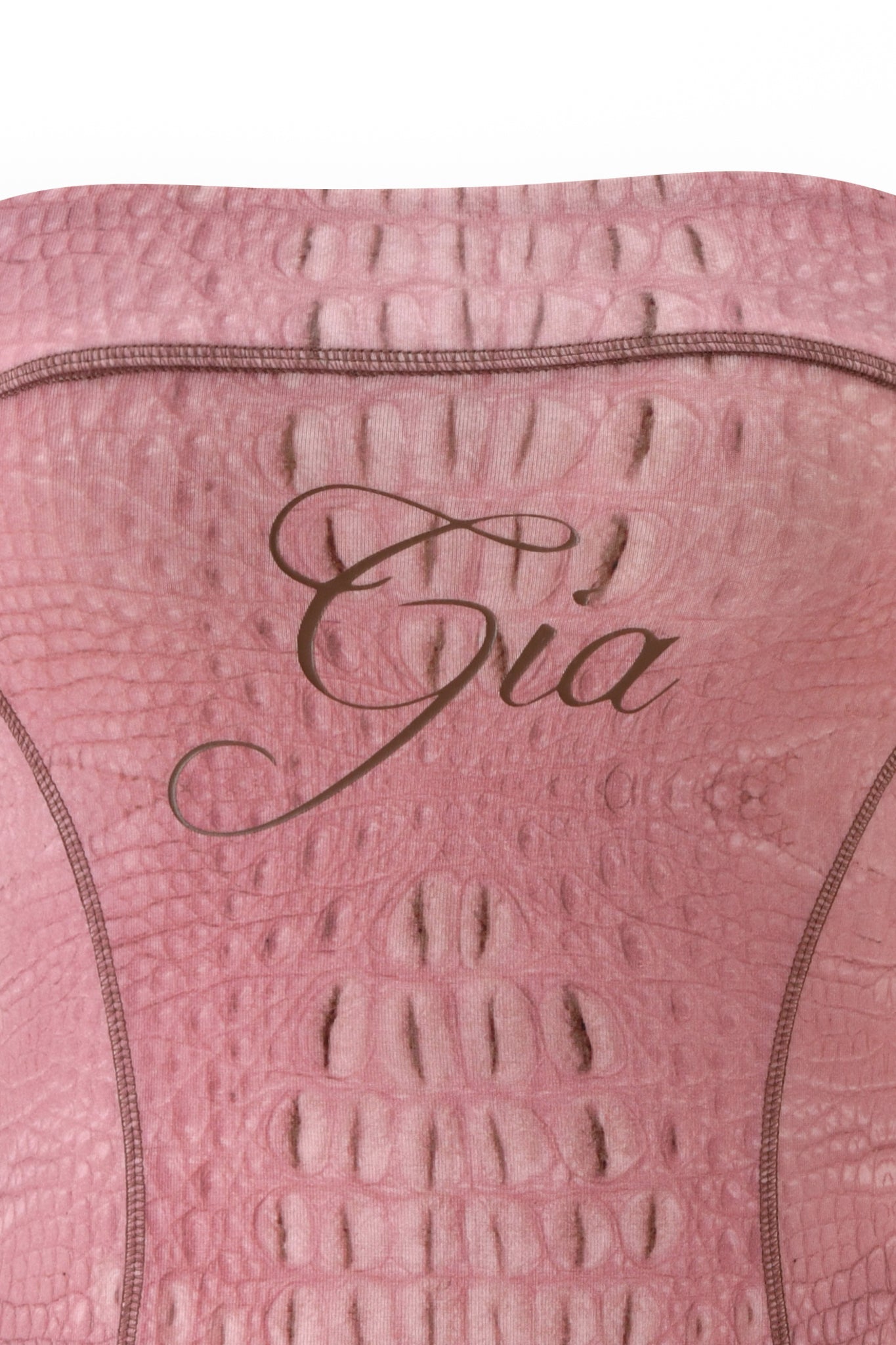 A close-up of the hot pink, crocodile-patterned fabric from the BLARE TUBE MINI DRESS by I.AM.GIA, featuring the word “Gia” elegantly scripted across the center.