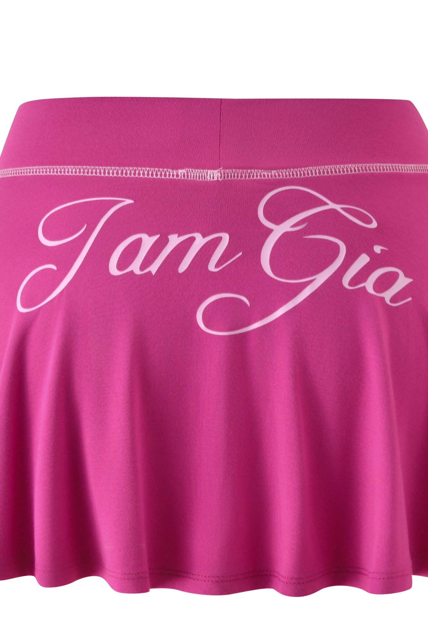 The BLARE SKORT - RASPBERRY by I.AM.GIA features a vibrant pink hue with the brand’s name in large, white cursive lettering across the waistband.
