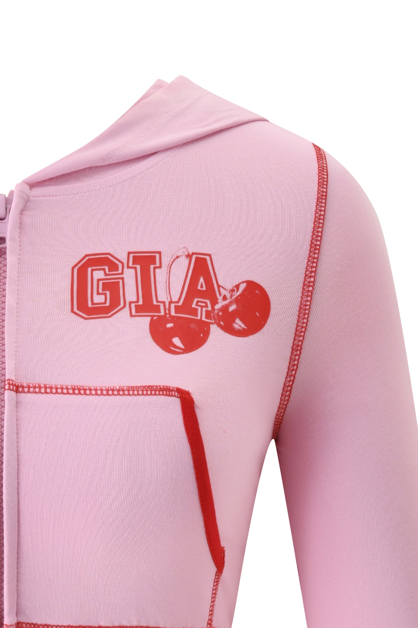 Close-up of the I.AM.GIA BLARE CROPPED HOODIE in baby pink, featuring red stitching, bold red "GIA" lettering, and two red cherry graphics on the chest.