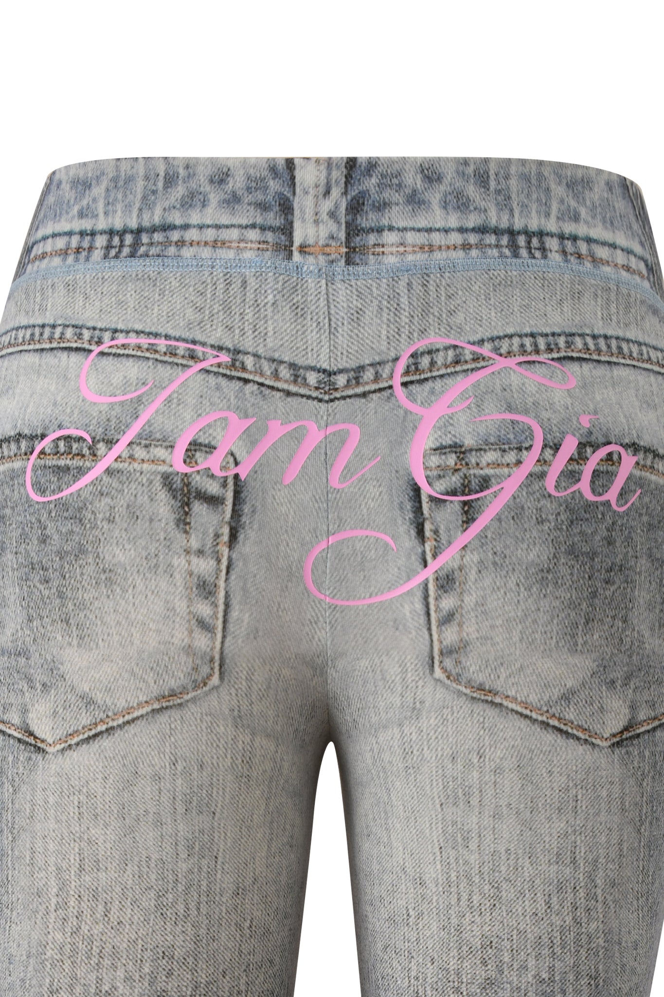 A close-up of the back of light blue I.AM.GIA BLARE CAPRI - DENIM TROMPE L'OEIL jeans with two pockets and pink "Tam Gia" cursive text across the faux-denim capri.