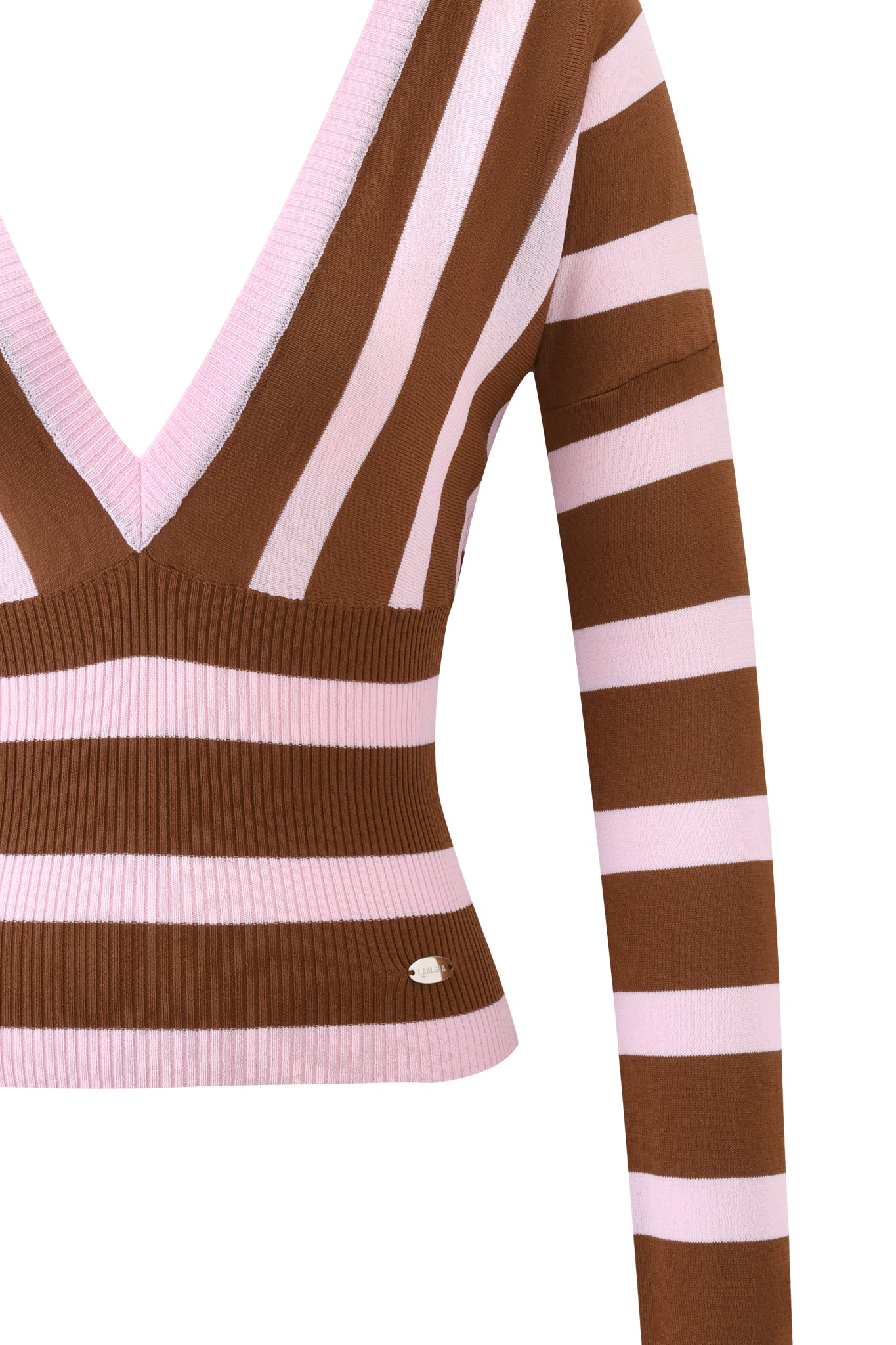 A close-up of the SUZI SWEATER - PINK AND CHOCOLATE STRIPE by I.AM.GIA, a cropped, long-sleeve V-neck with wide brown and pink stripes, bodycon fit in knit fabric, and a small metallic logo near the hem.