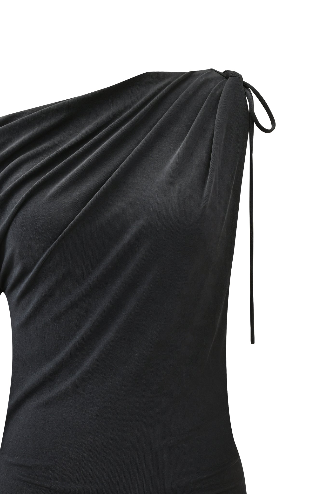 A close-up of the I.AM.GIA JOLIE MINI DRESS - STEEL showcases its black, asymmetrical one-sleeve design with soft draping and a thin tie at the shoulder, set against a white background to highlight its elegant texture.