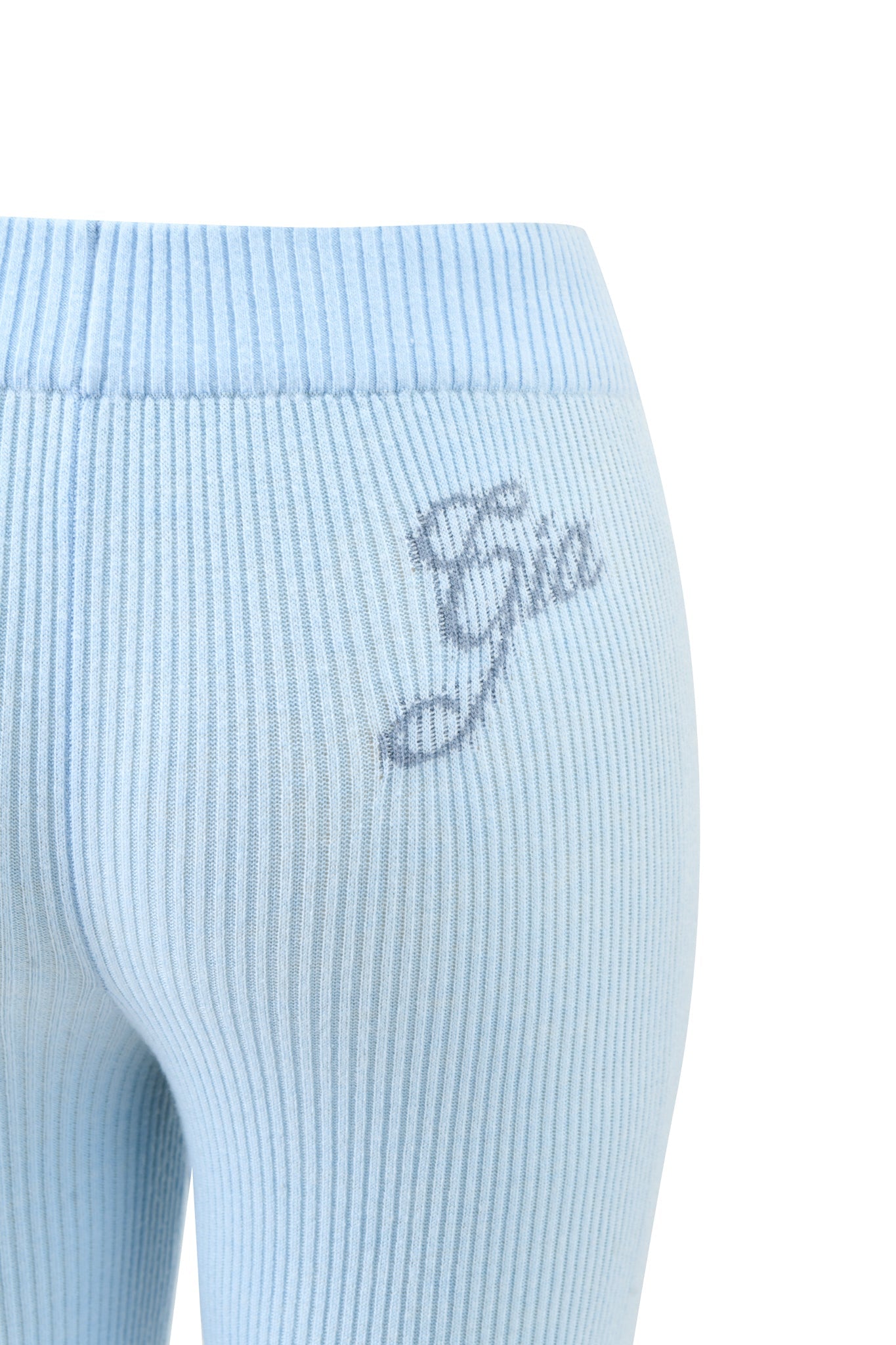 Close-up of the BLARE KNIT TRACKPANT in blue by I.AM.GIA, featuring light blue ribbed knit fabric, a flared leg, and "Gia" embroidered in gray on the upper hip. Ideal for fans of I.AM.GIA style.