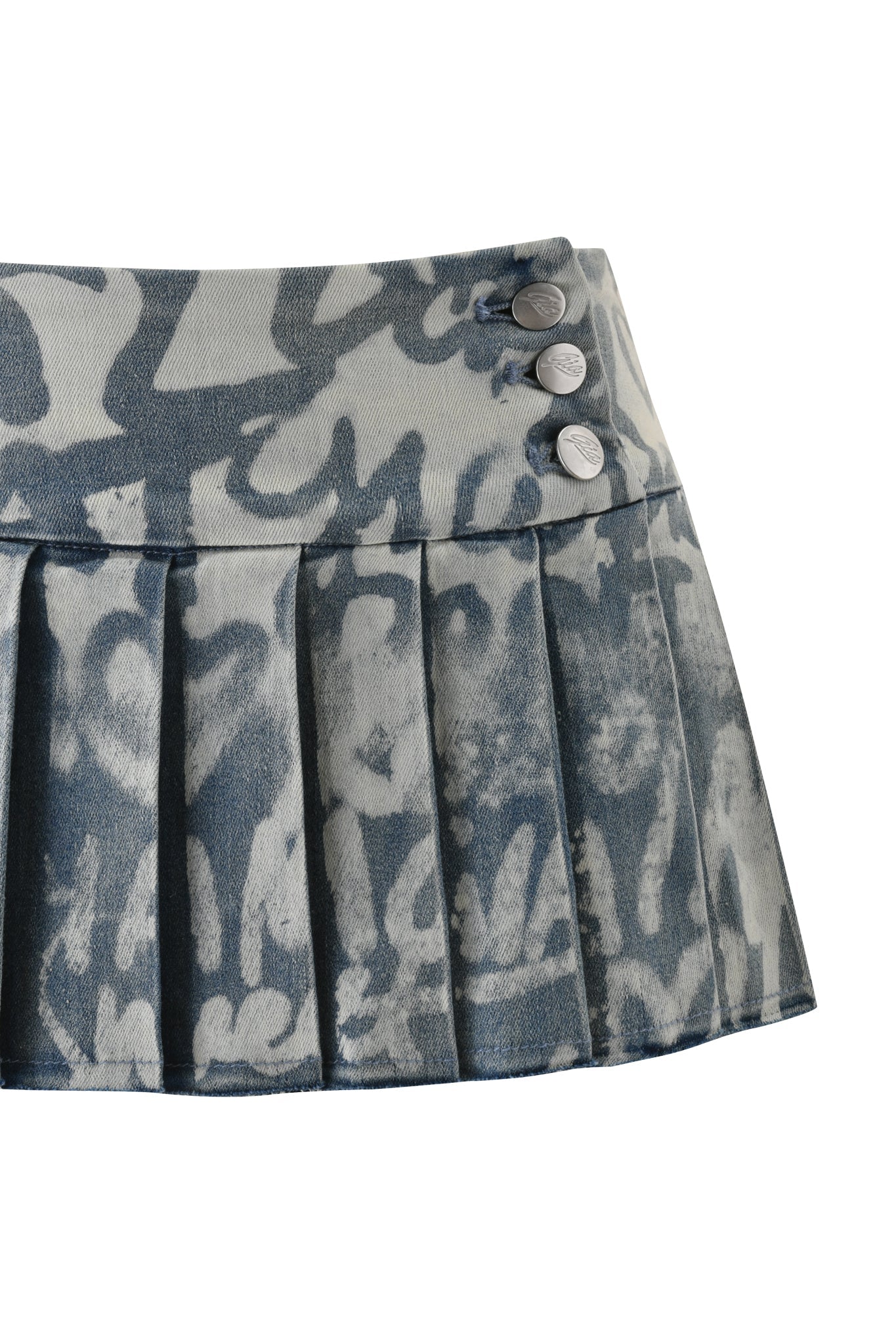 A close-up of the I.AM.GIA REMINI DISTRESSED DENIM SKORT in Graffiti Light Wash, showcasing its blue and white graffiti print and three metallic buttons on the waistband.