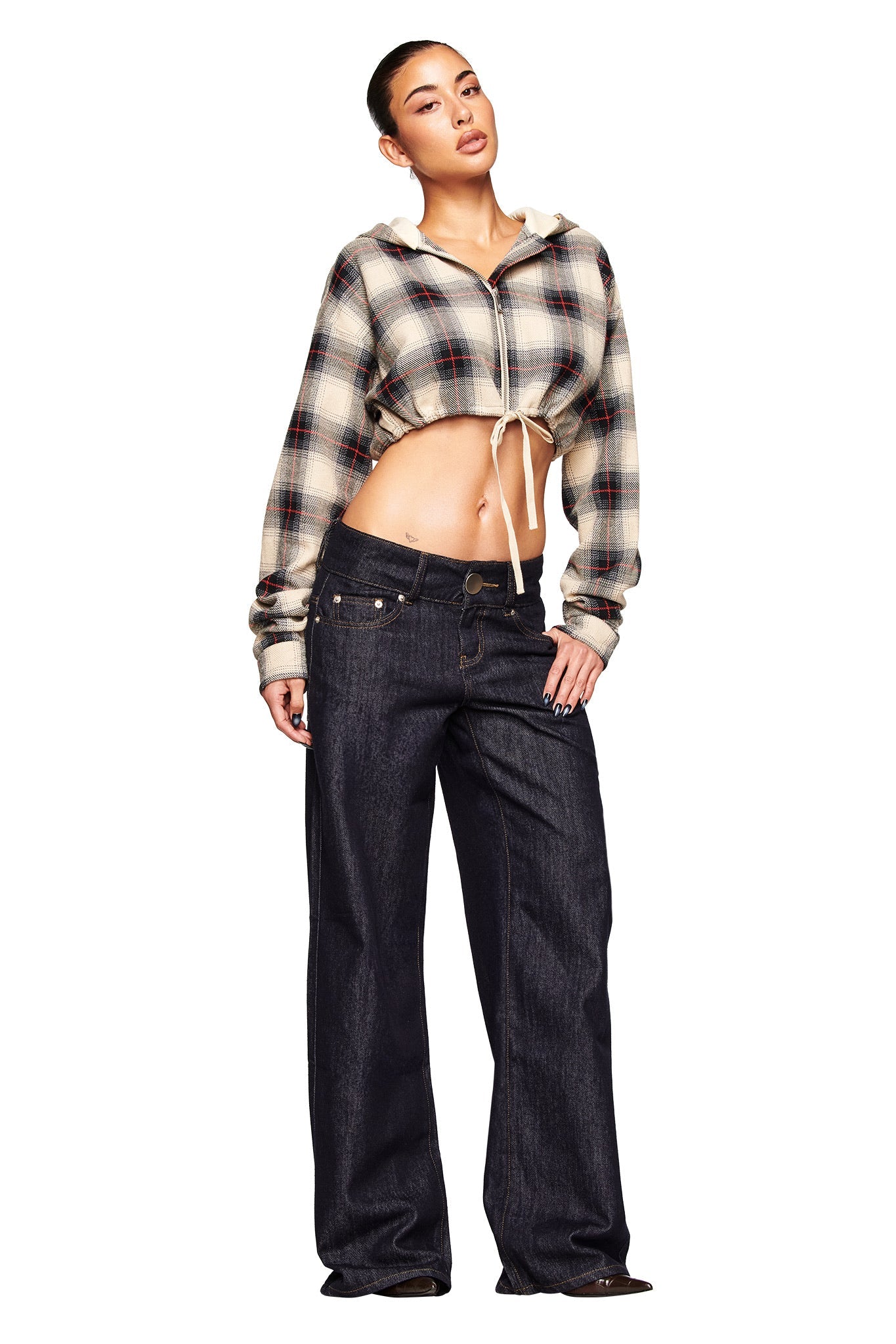 A woman models the I.AM.GIA TIFF JACKET in grey plaid with loose dark jeans, one hand in her pocket and the other on her leg, posing against a white background.