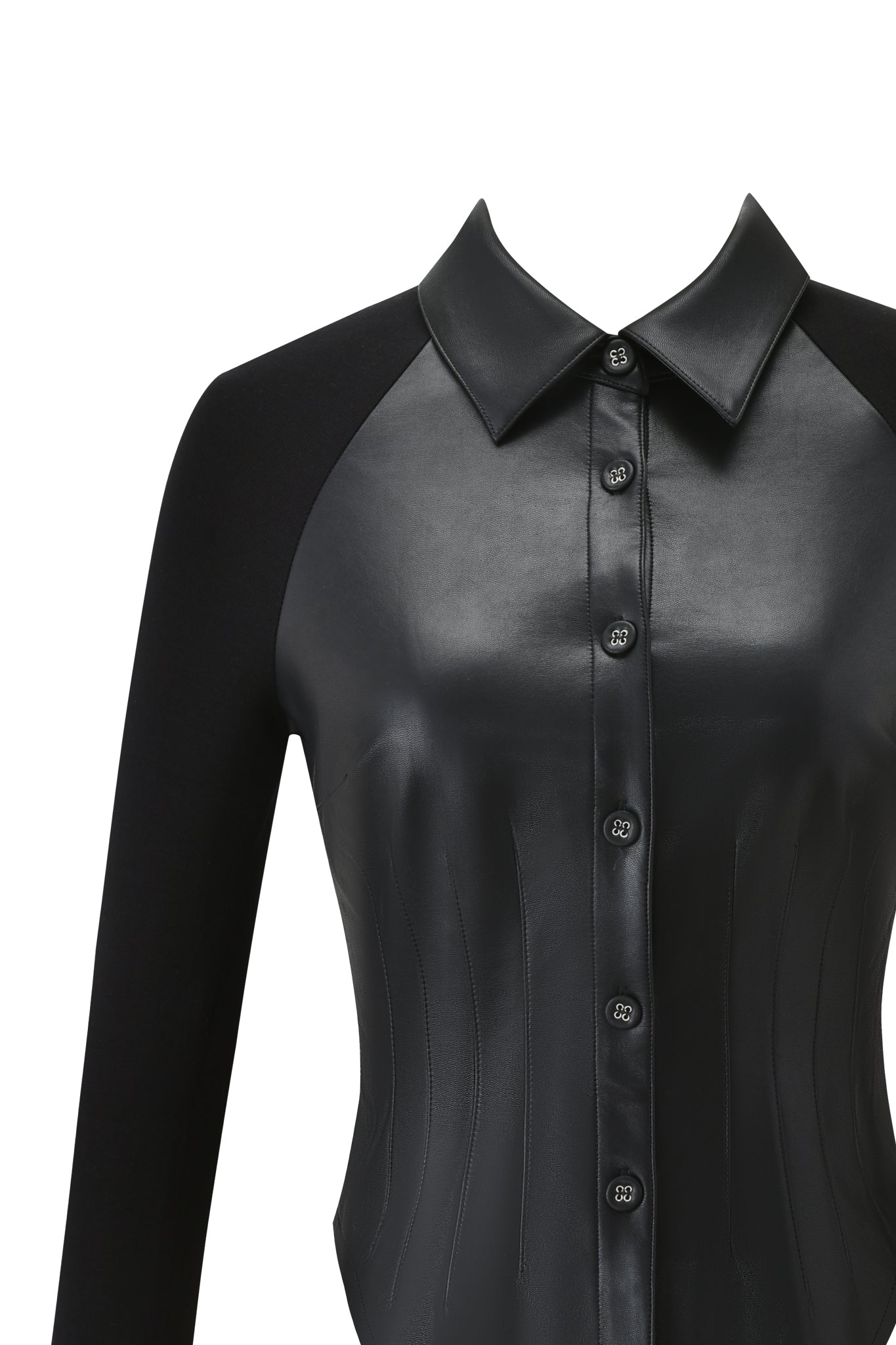 A close-up of the I.AM.GIA HELIX TOP - BLACK, a bodycon faux leather shirt with button-down closure and pointed collar. Matte black fabric accents the sleeves and sides. Displayed against a white background.