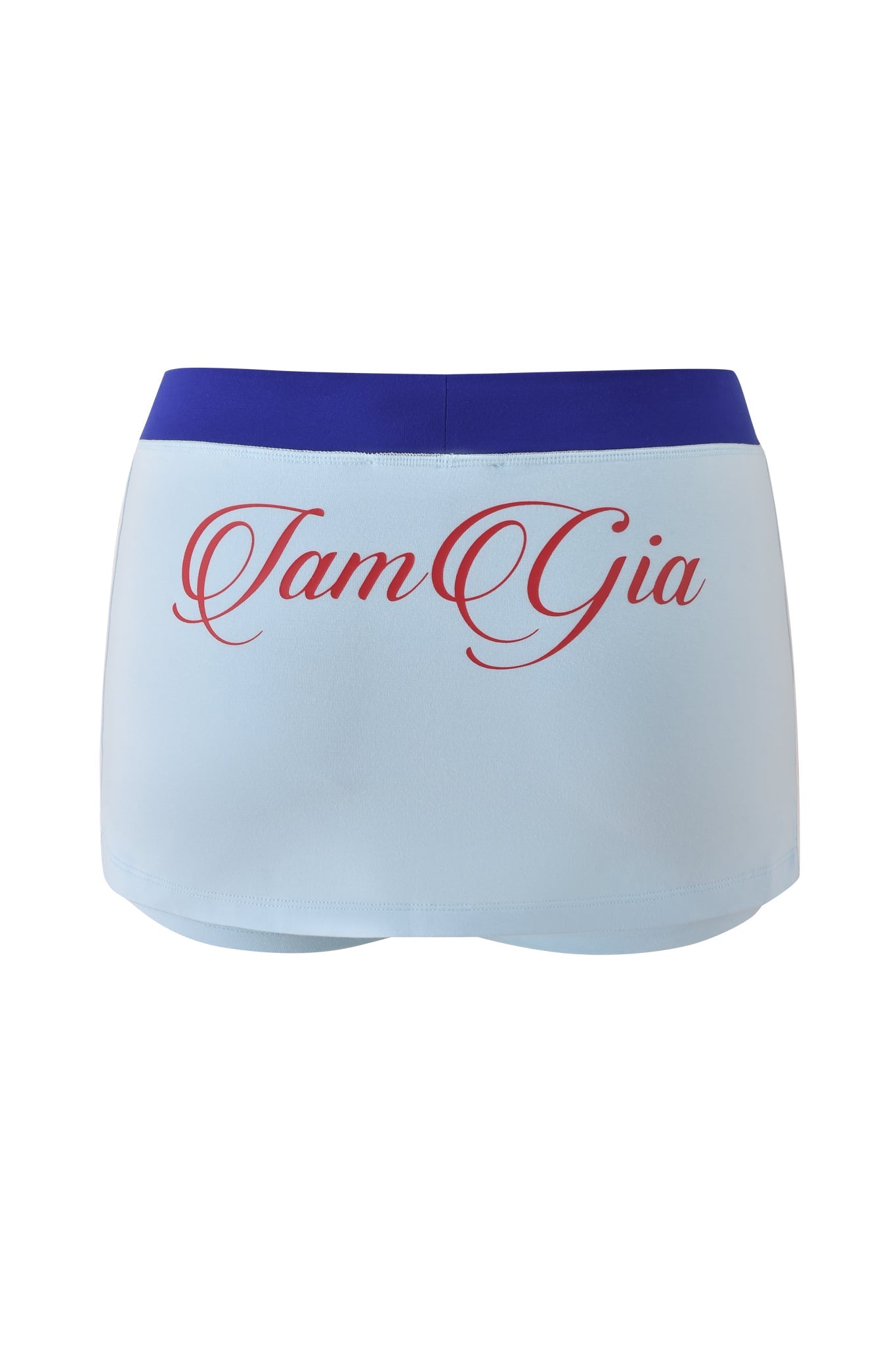The BLARE VARSITY MICRO SKORT by I.AM.GIA features buttery-soft baby blue fabric, a wide royal blue waistband, and bold “I.AM.GIA” lettering in large red cursive on the back.