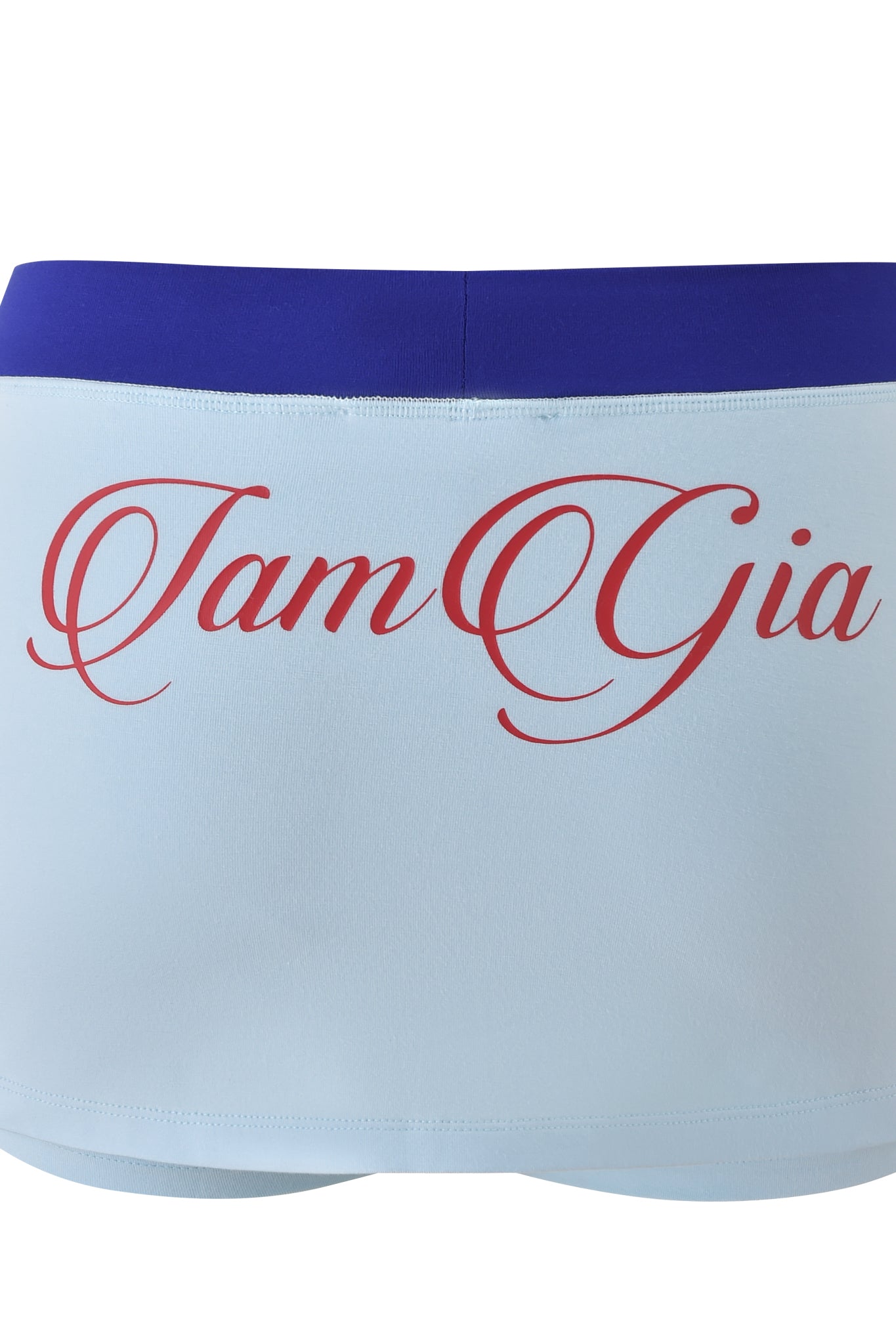 The BLARE VARSITY MICRO SKORT in baby blue by I.AM.GIA features a wide blue waistband, bold red "I.AM.GIA" cursive on the back, and is crafted from buttery-soft fabric for all-day comfort.