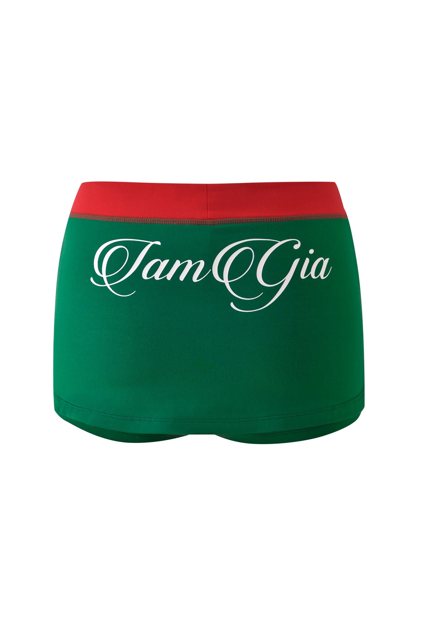 The BLARE VARSITY MICRO SKORT - GREEN by I.AM.GIA features a red waistband, buttery-soft fabric, and “I.AM.GIA” in white cursive across the back for a playful, sporty look.