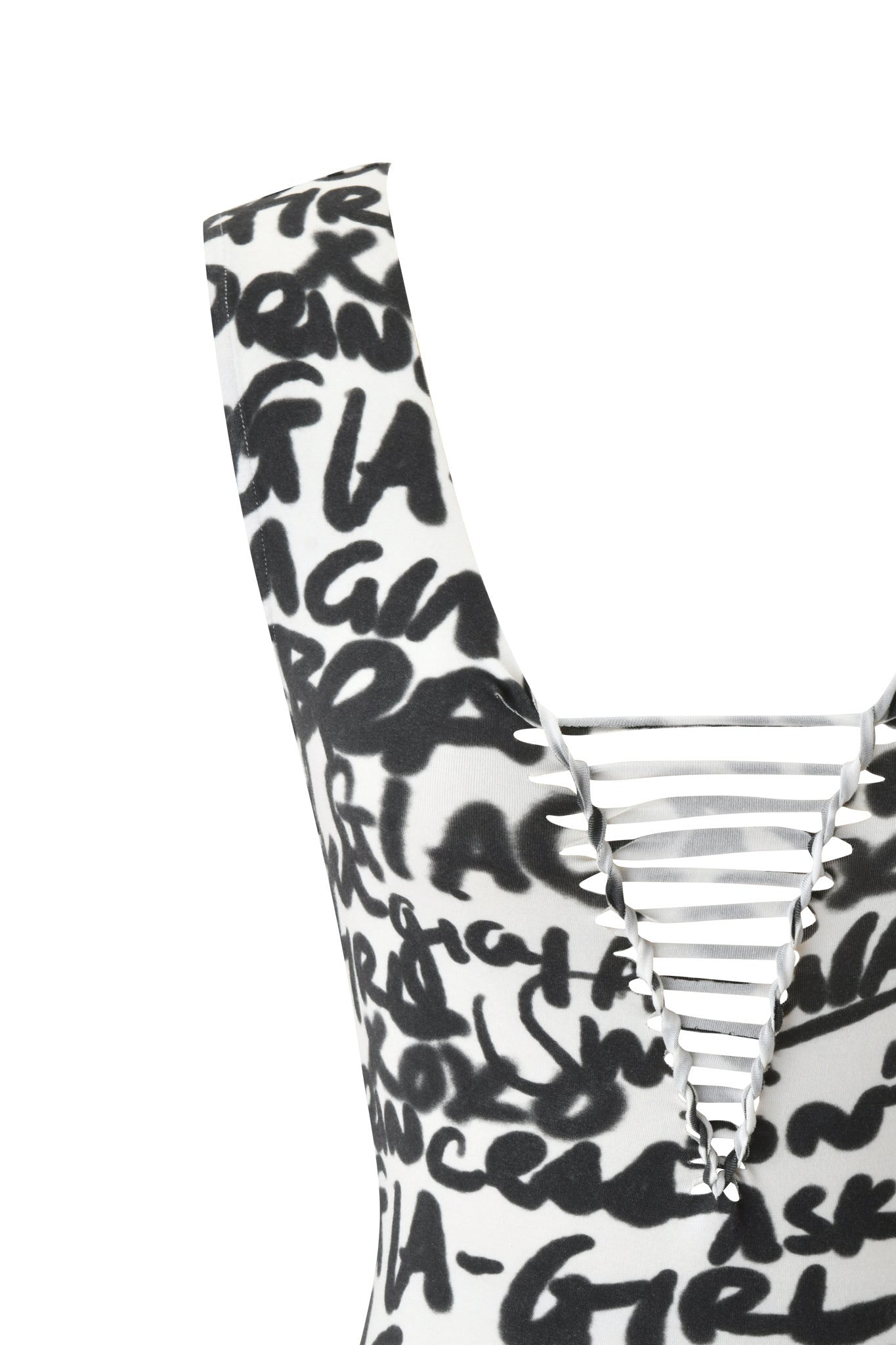 Close-up of the HONEY MACRAME TOP - WRITING ON THE WALL by I.AM.GIA, featuring a bold black graffiti print on white and a deep V-neck with horizontal white straps.