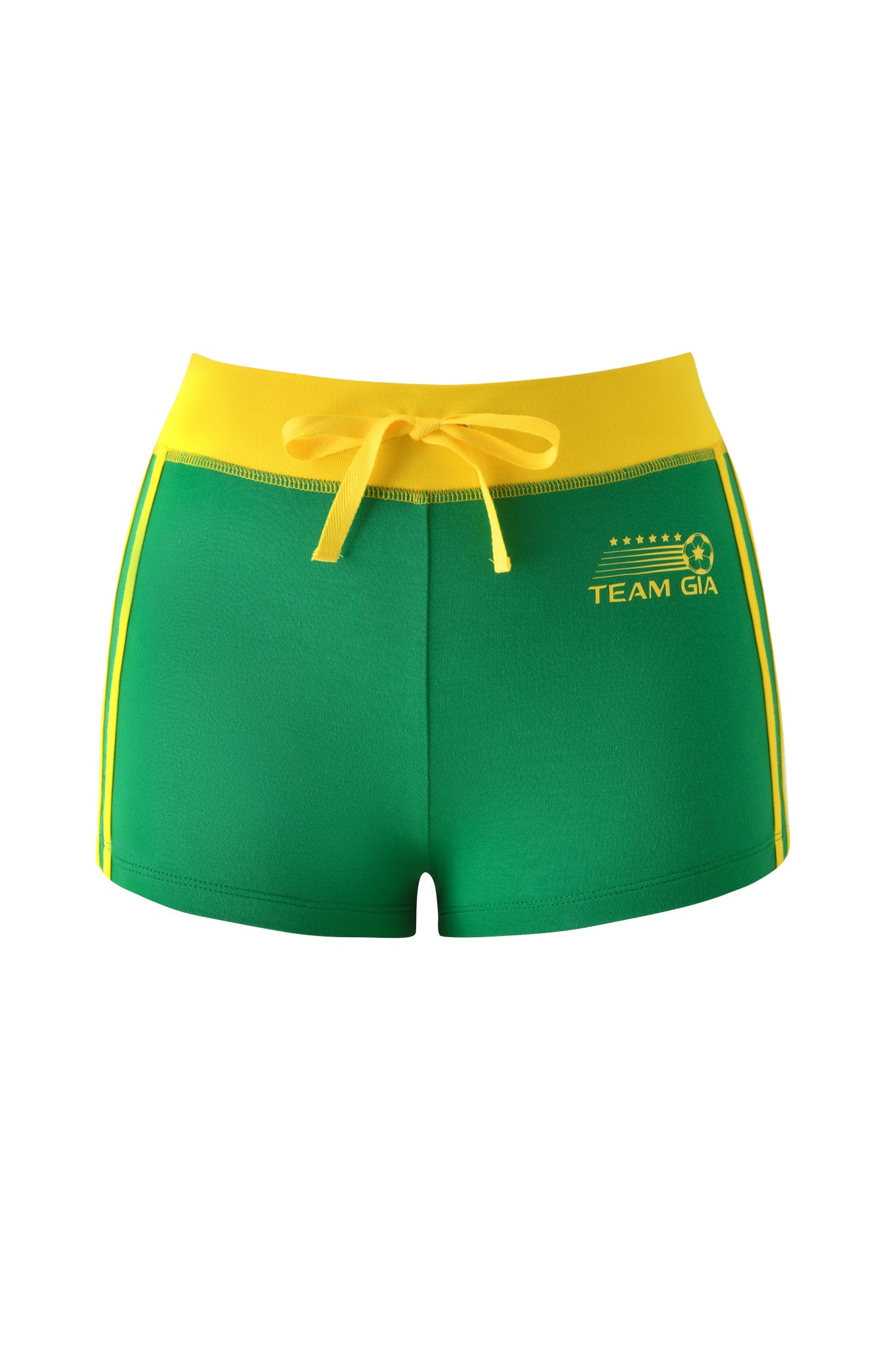 The BLARE PIPING SHORT - GREEN by I.AM.GIA features a yellow waistband and side stripes, drawstring, and "TEAM GIA" logo with stars and a soccer ball on the left front.