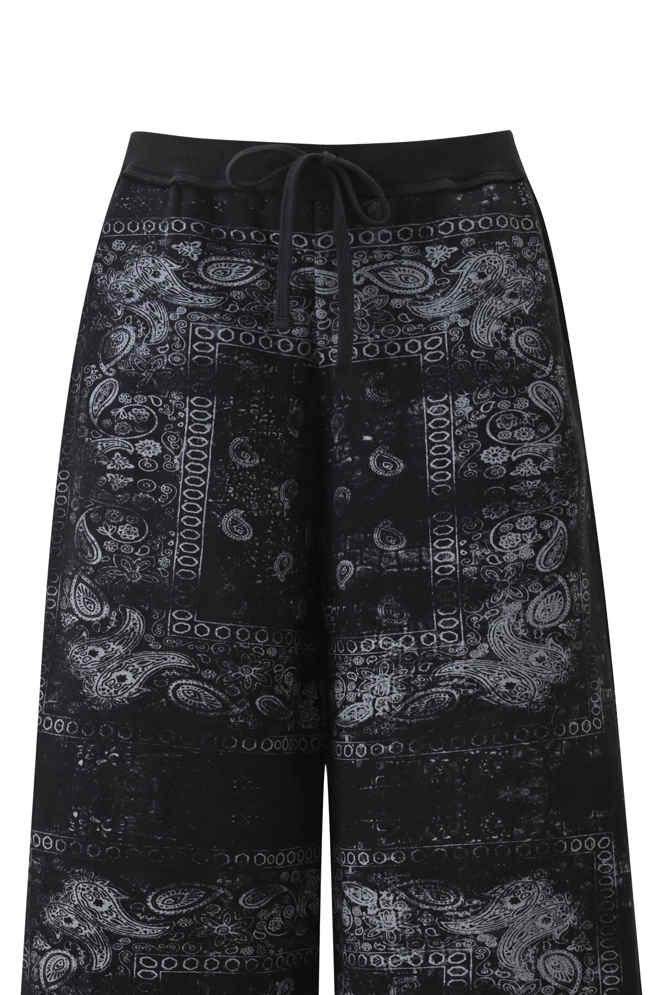 The I.AM.GIA T-REX TRACKPANT - BLACK BANDANA features black wide-leg pants adorned with a white paisley and geometric bandana print, a drawstring waistband, and a relaxed street style fit.